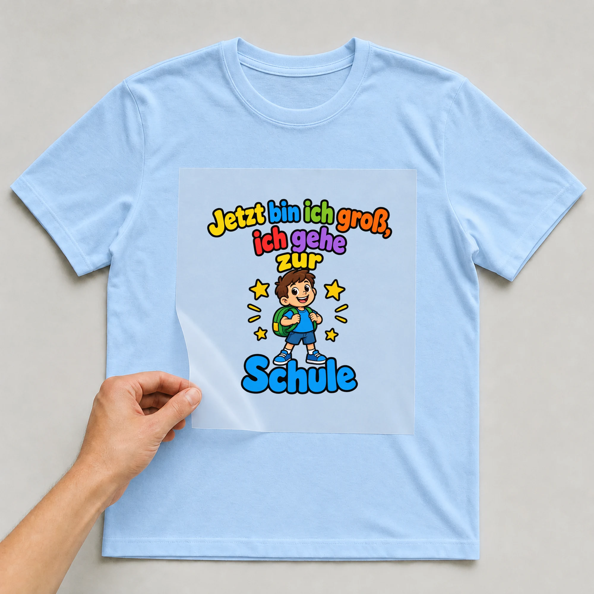 Bügelbild „Jetzt bin ich gross ich gehe“ auf babyblauem T-Shirt, Folie wird aufgelegt