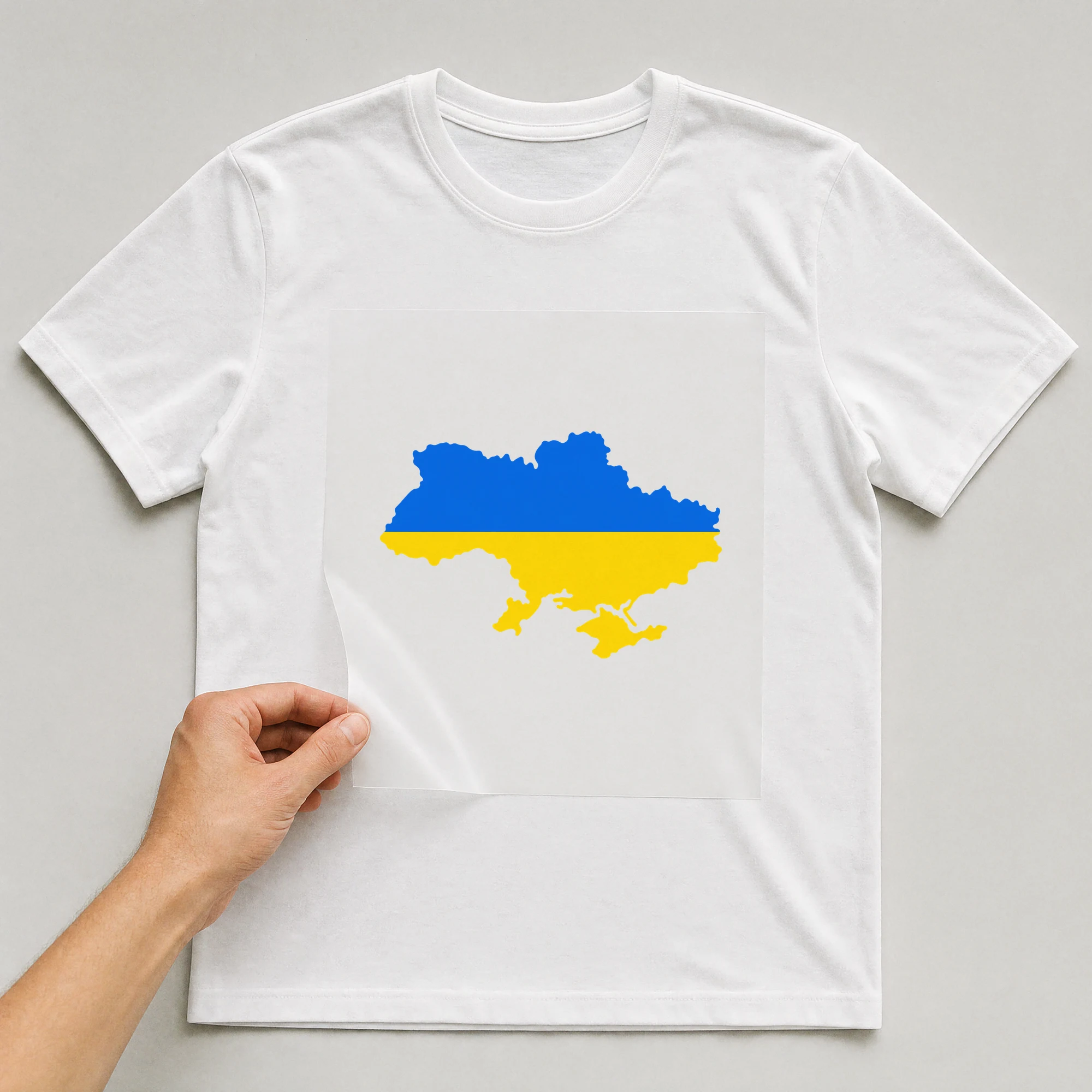 Bügelbild „Peace Ukraine Land“ auf weißem T-Shirt, Folie wird aufgelegt