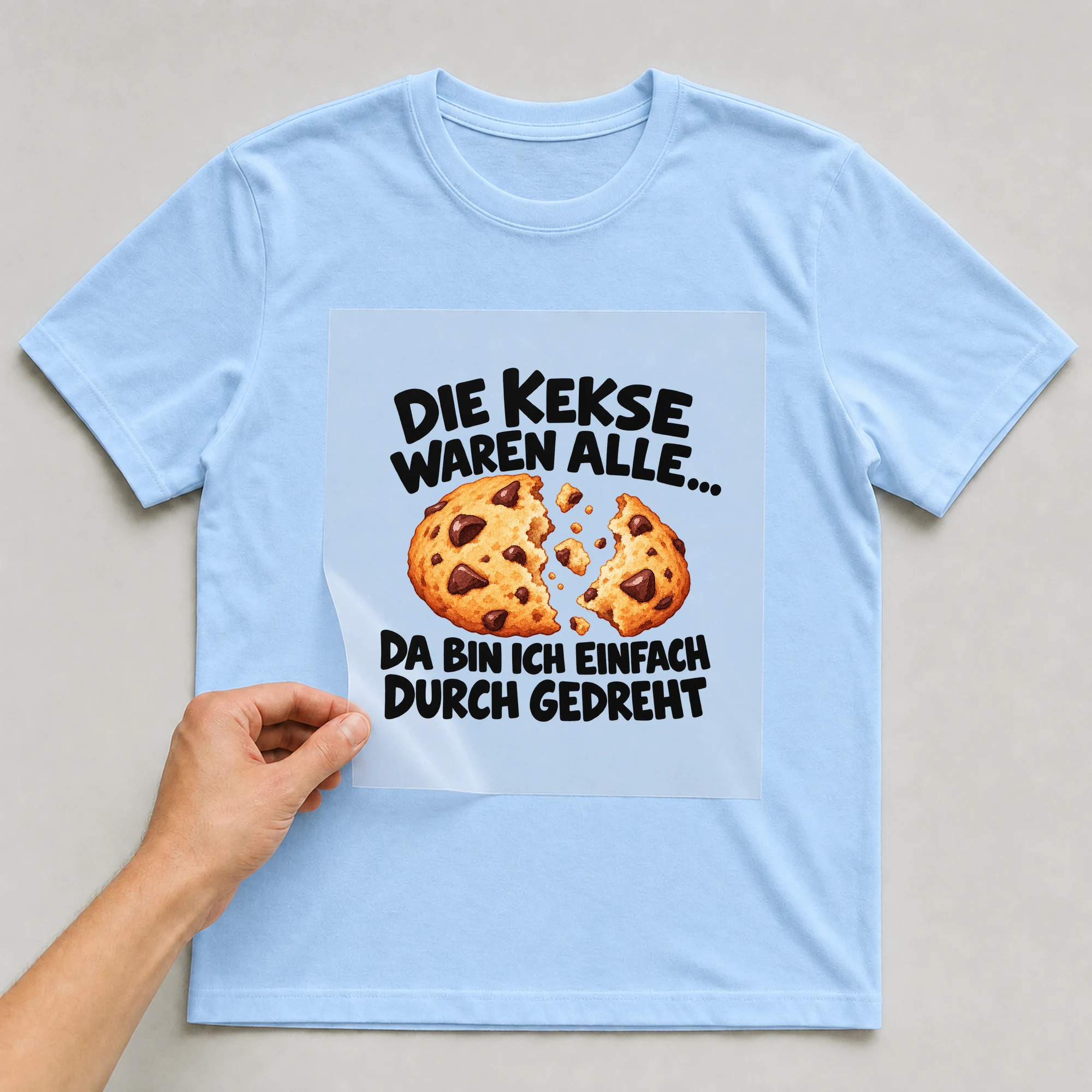 Bügelbild „Die Kekse waren alle... Da bin ich einfach durch gedreht“ auf babyblauem T-Shirt, Folie wird aufgelegt