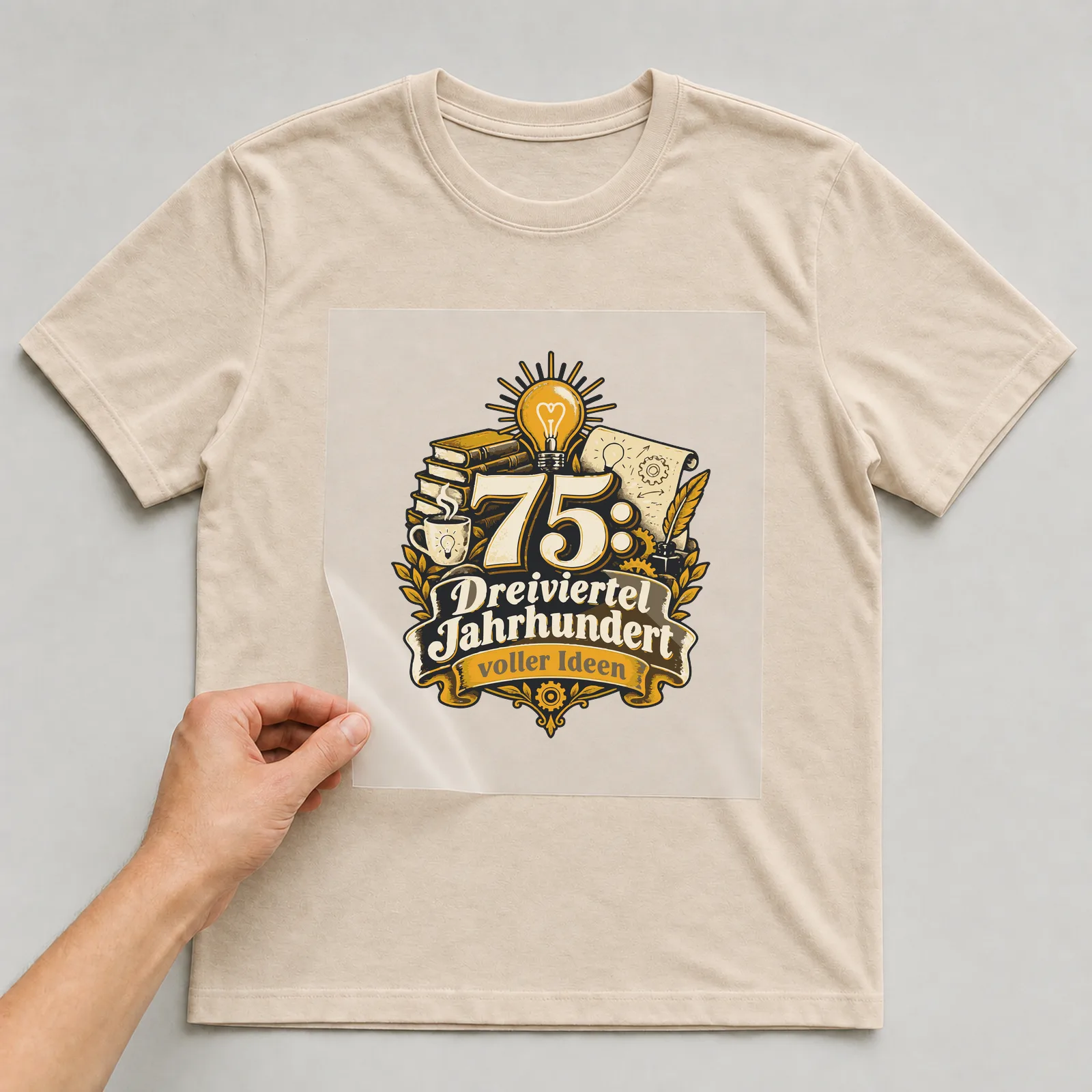 Bügelbild 75: Dreiviertel Jahrhundert voller Ideen auf beigem T-Shirt, Folie wird aufgelegt