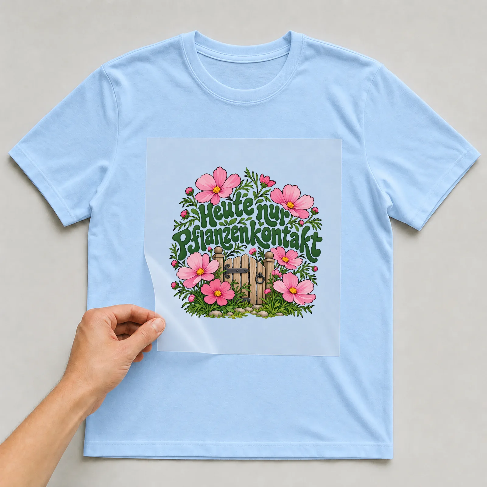 Bügelbild „Heute nur Pflanzenkontakt“ auf hellblauem T-Shirt, Folie wird aufgelegt