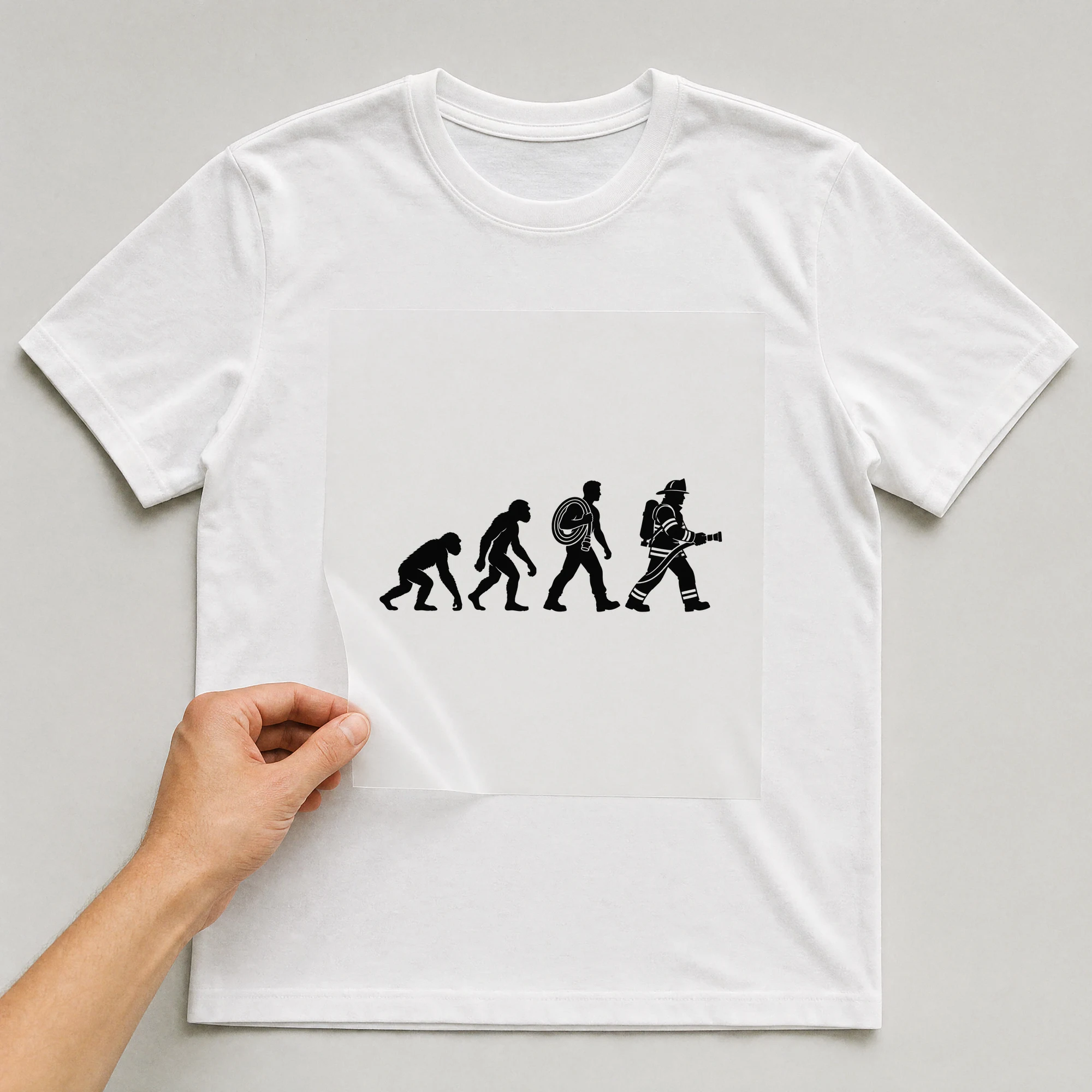 Bügelbild „Evolution Firefighter“ auf weißem T-Shirt, Folie wird aufgelegt