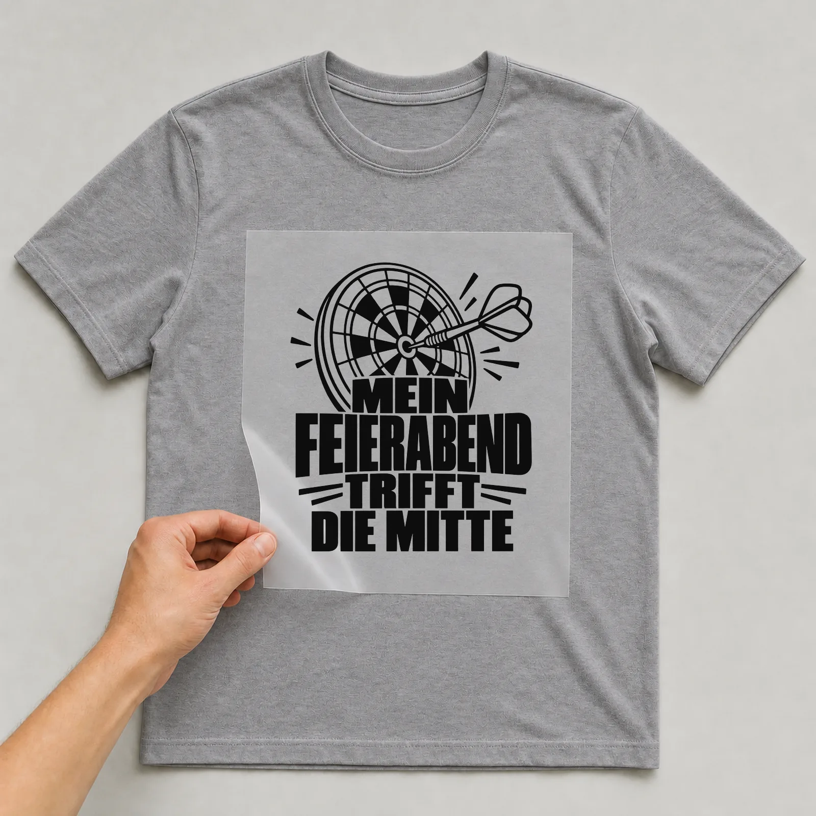 Bügelbild „Mein Feierabend trifft die Mitte“ auf grauem T-Shirt, Folie wird aufgelegt