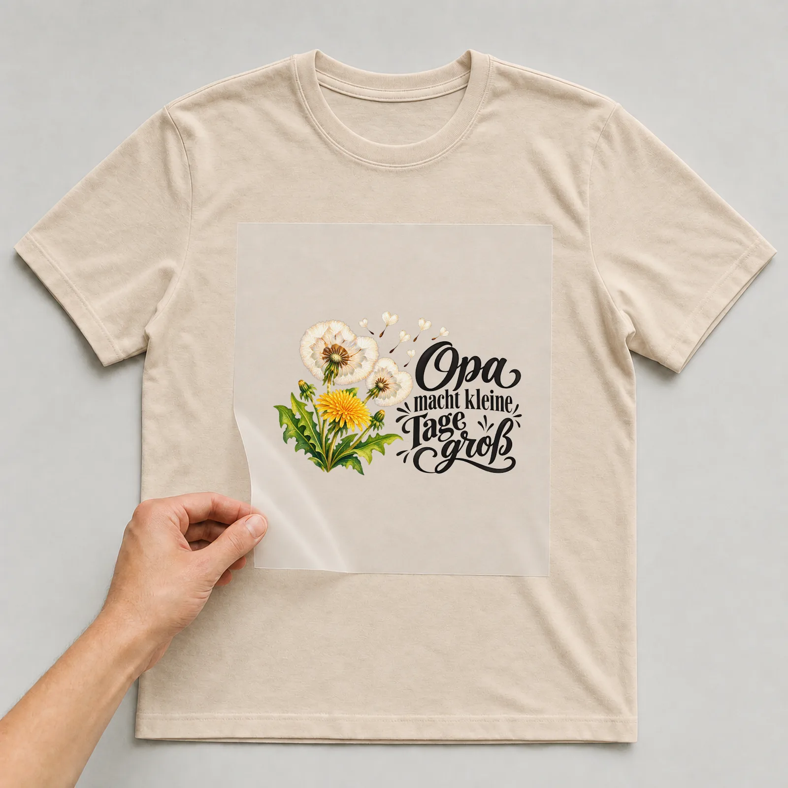 Bügelbild „Opa macht kleine Tage groß“ auf beigem T-Shirt, Folie wird aufgelegt