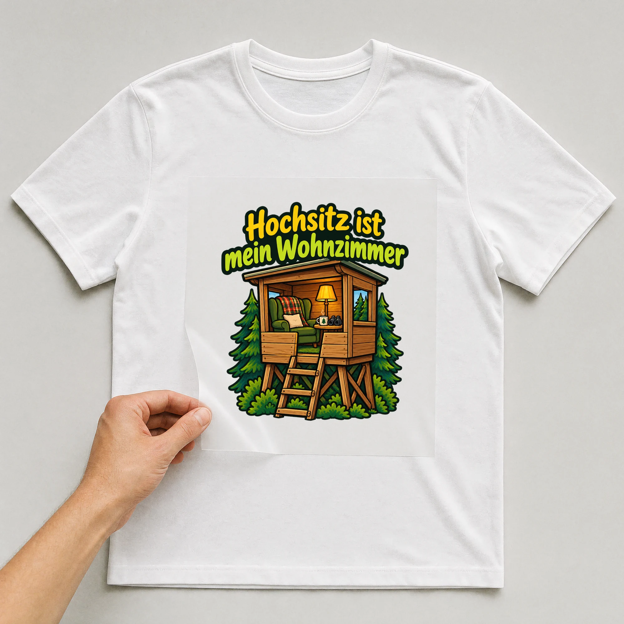 Bügelbild „Hochsitz ist mein Wohnzimmer“ auf weißem T-Shirt, Folie wird aufgelegt