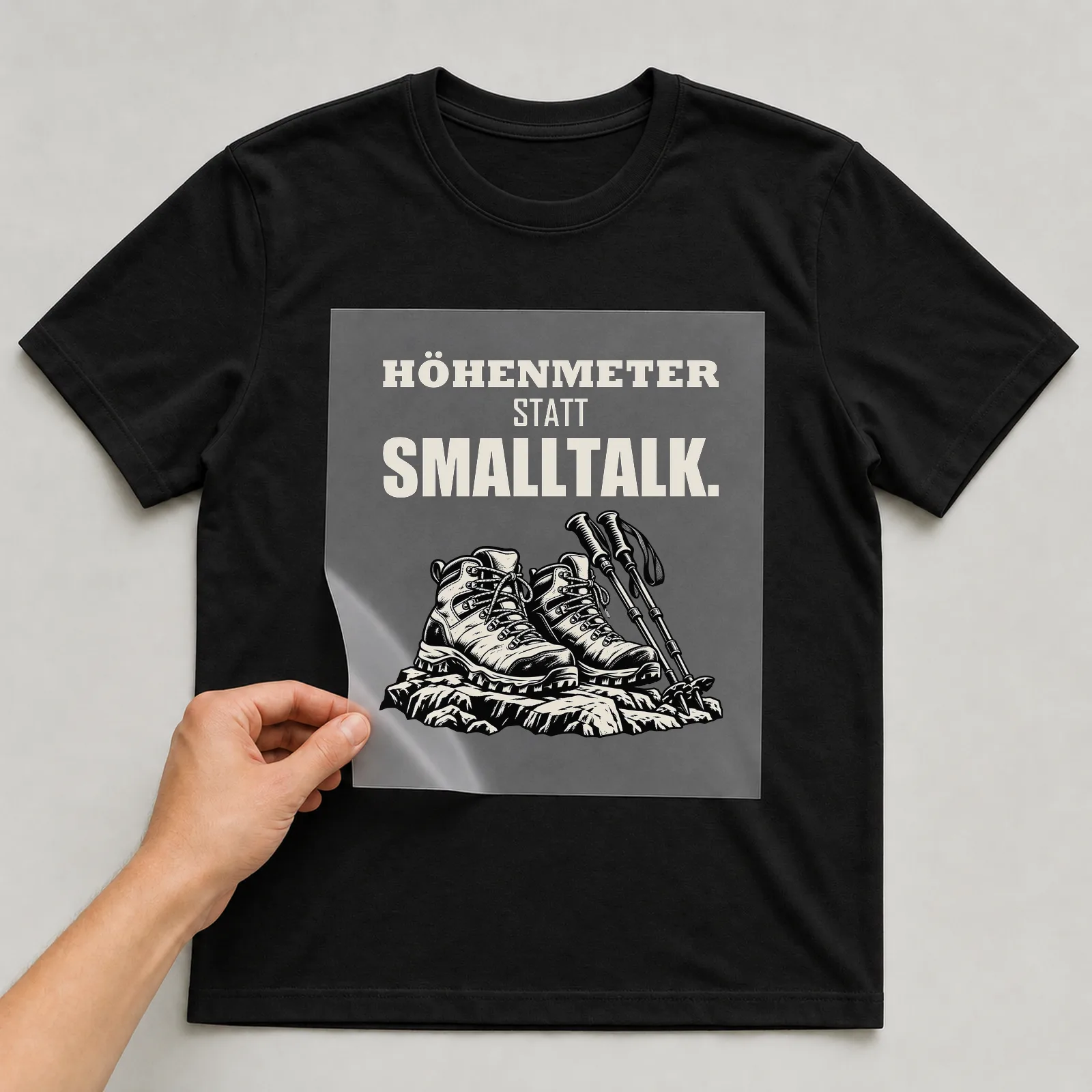 Bügelbild „Höhenmeter statt Smalltalk“ auf schwarzem T-Shirt, Folie wird aufgelegt