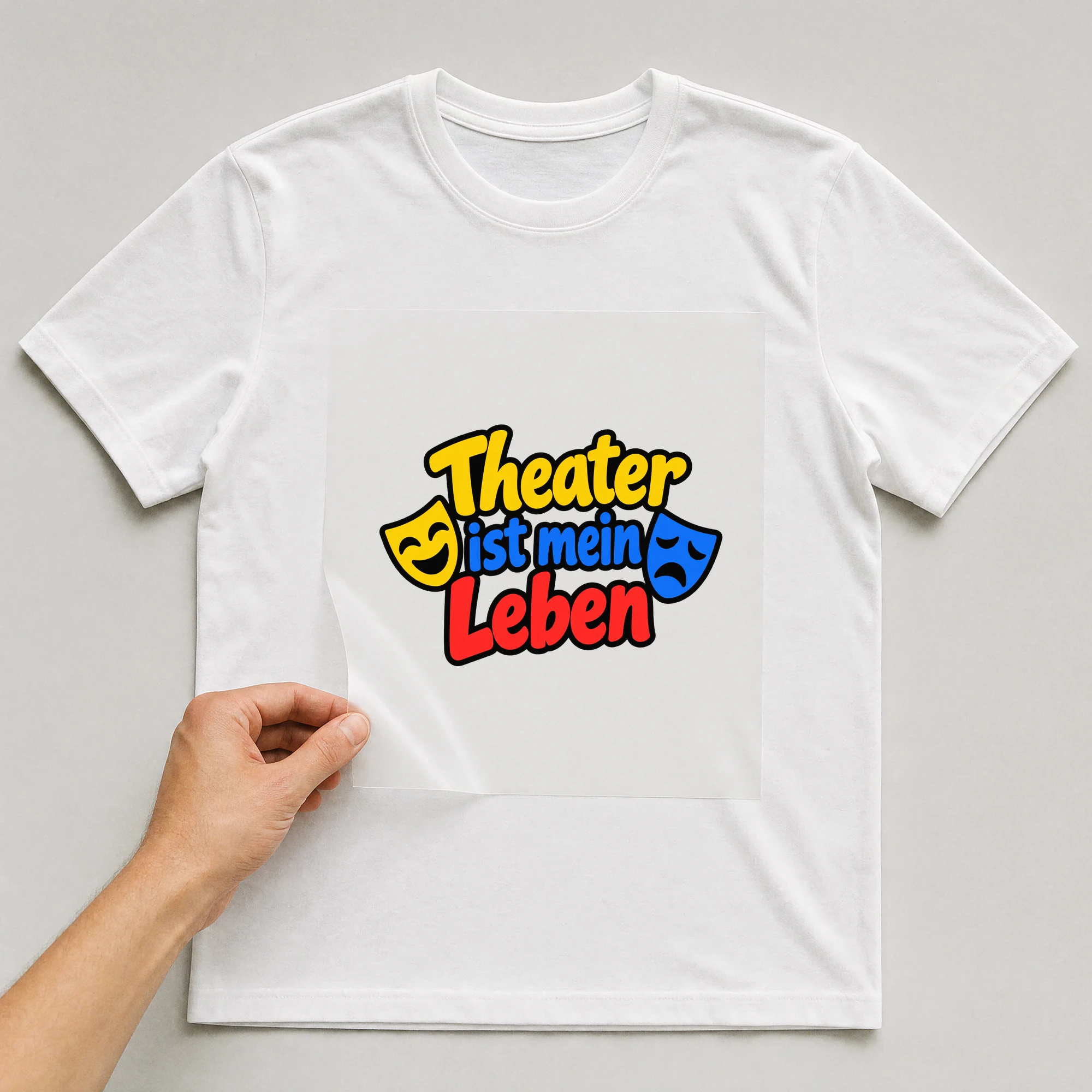 Bügelbild „Theater ist mein Leben“ auf weißem T-Shirt, Folie wird aufgelegt