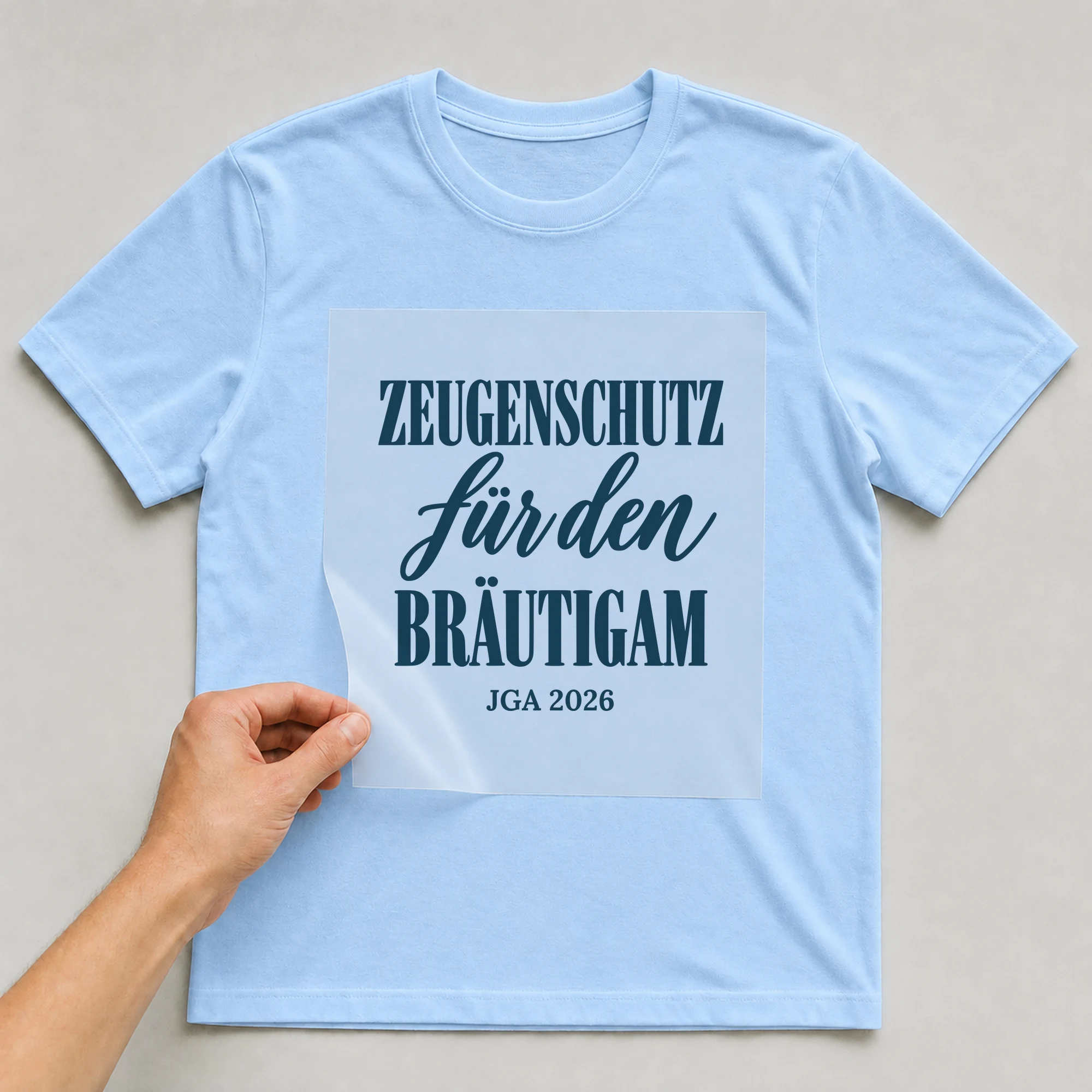 Bügelbild Zeugenschutz für den Bräutigam mit Jahr auf hellblauem T-Shirt, Folie wird aufgelegt