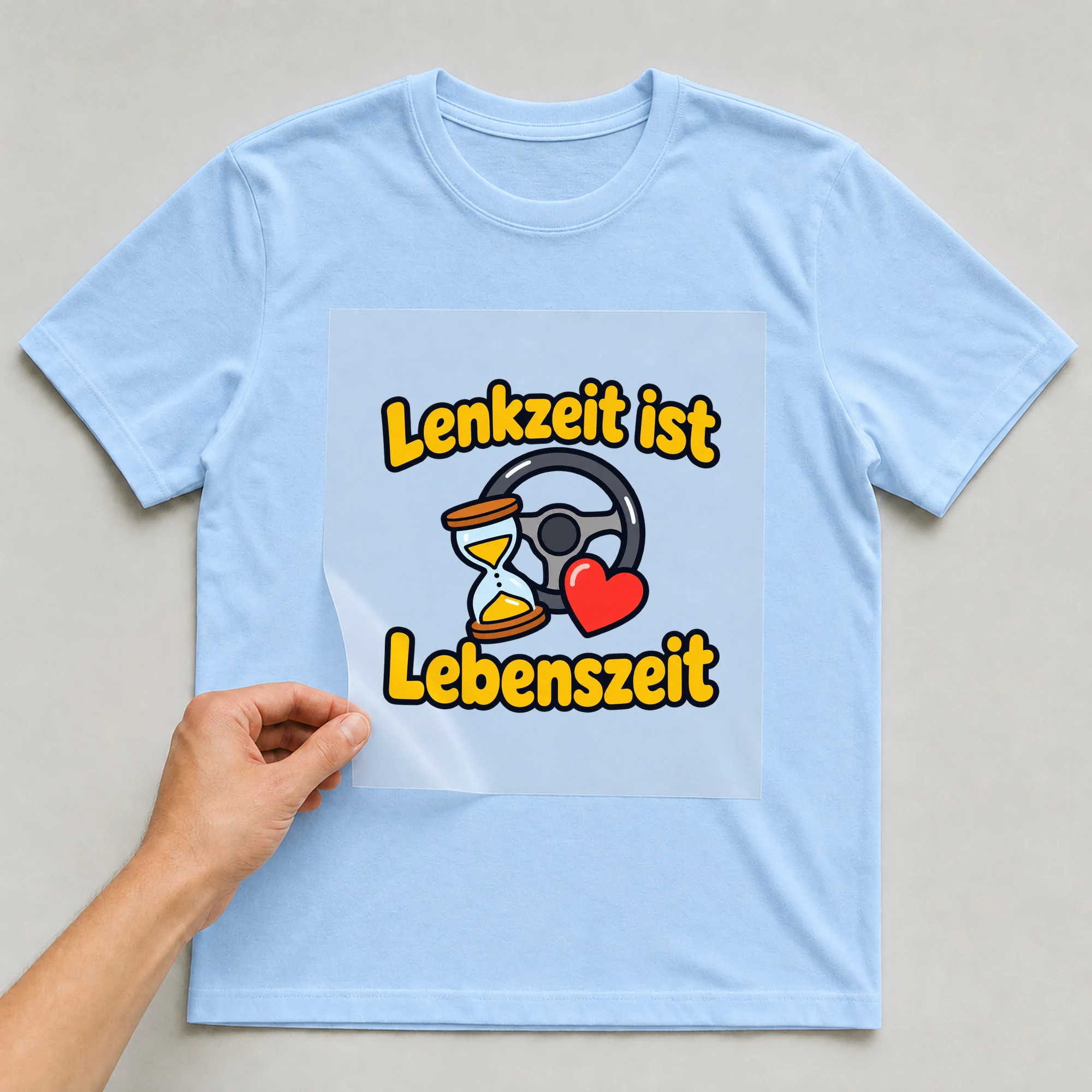 Bügelbild „Lenkzeit ist Lebenszeit“ auf babyblauem T-Shirt, Folie wird aufgelegt