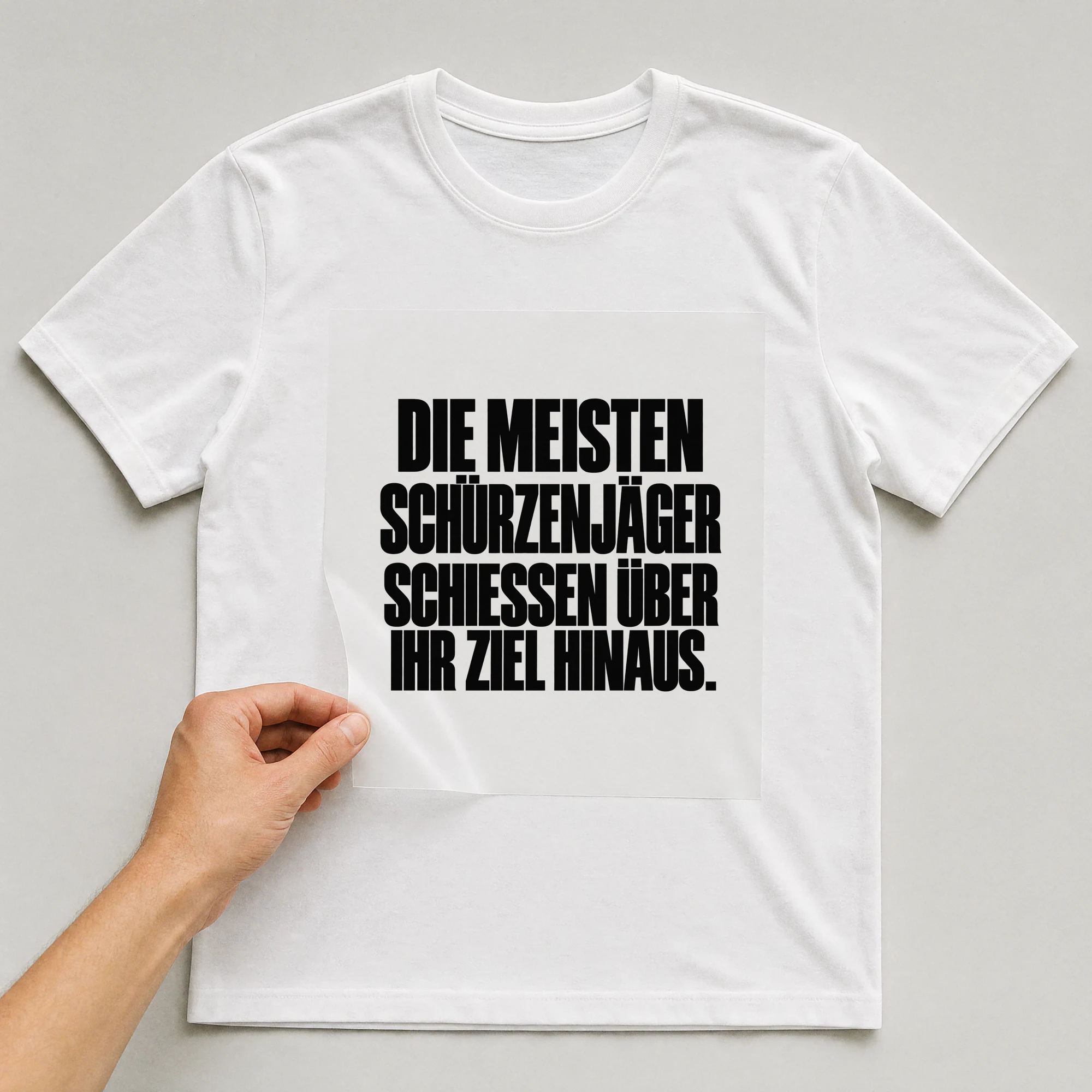 Bügelbild „Die meisten Schürzenjäger schießen über ihr Ziel hinaus.“ auf weißem T-Shirt, Folie wird aufgelegt
