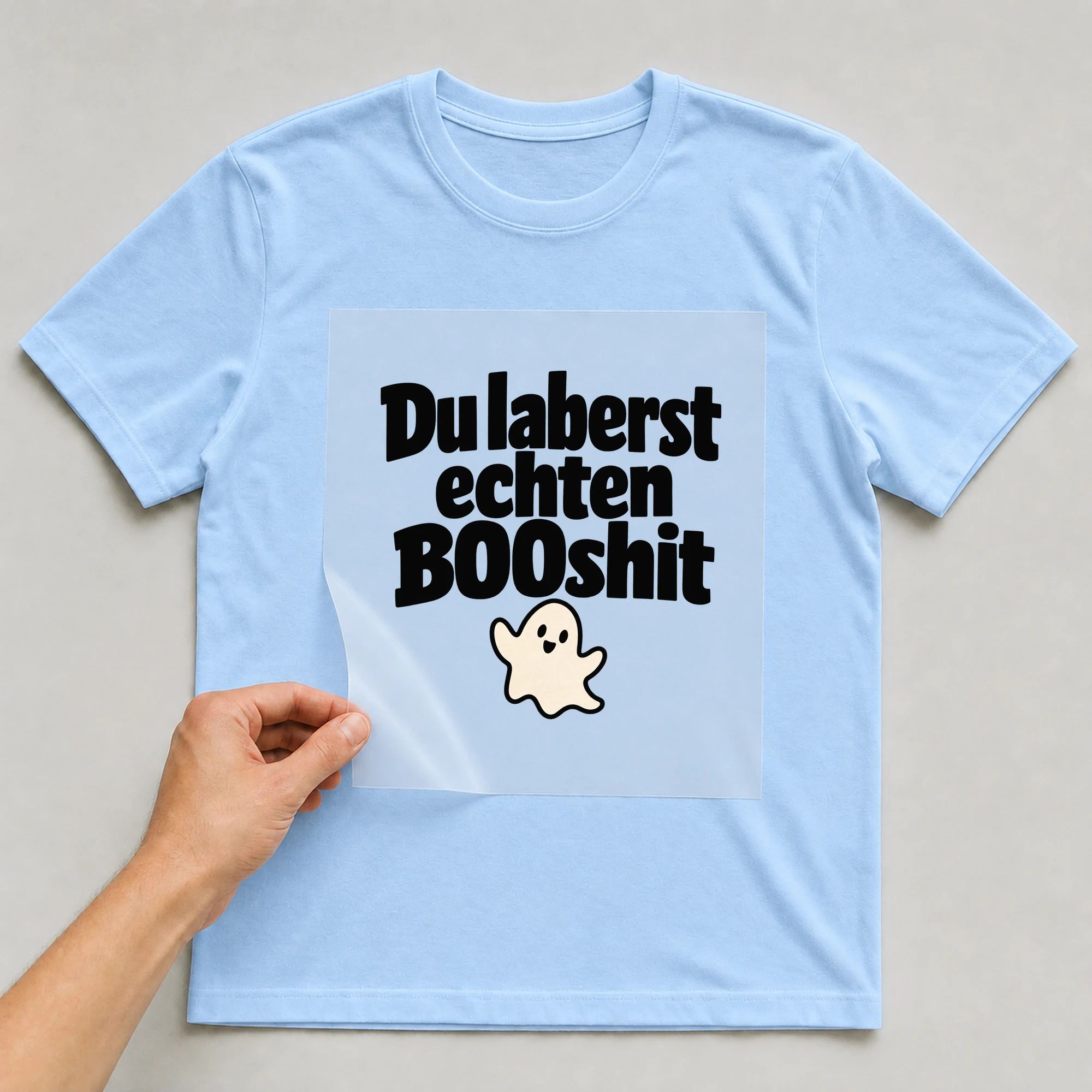 Bügelbild „Du laberst echten BOOshit“ auf babyblauem T-Shirt, Folie wird aufgelegt