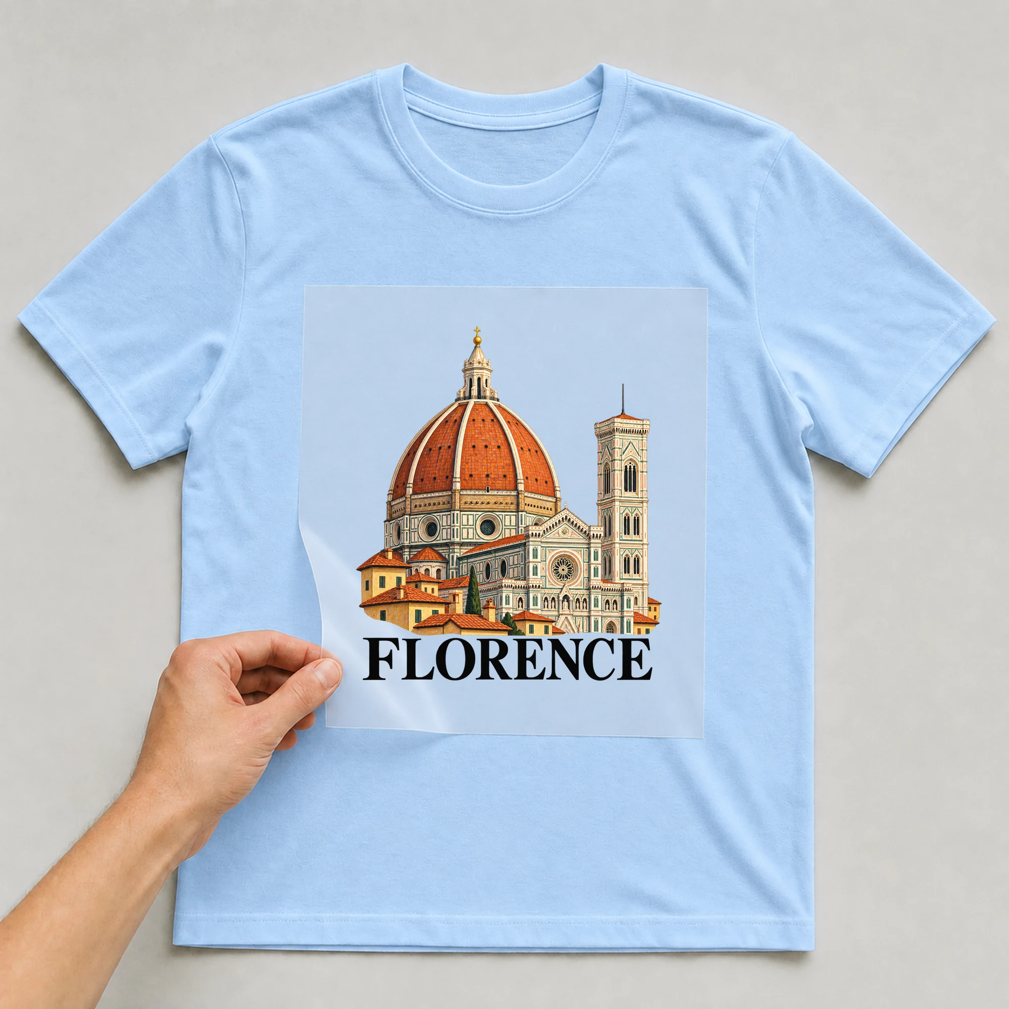 Bügelbild „Florence“ auf babyblauem T-Shirt, Folie wird aufgelegt