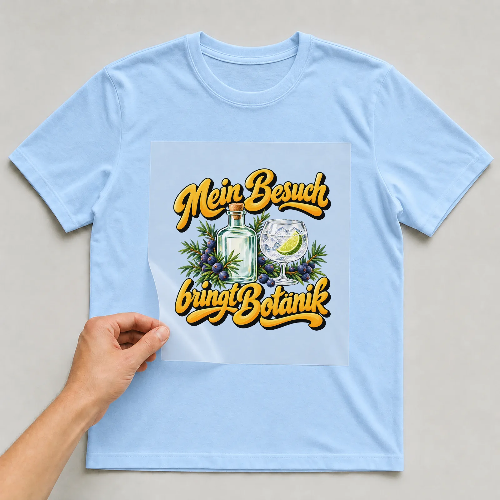 Bügelbild „Mein Besuch bringt Botanik“ auf hellblauem T-Shirt, Folie wird aufgelegt