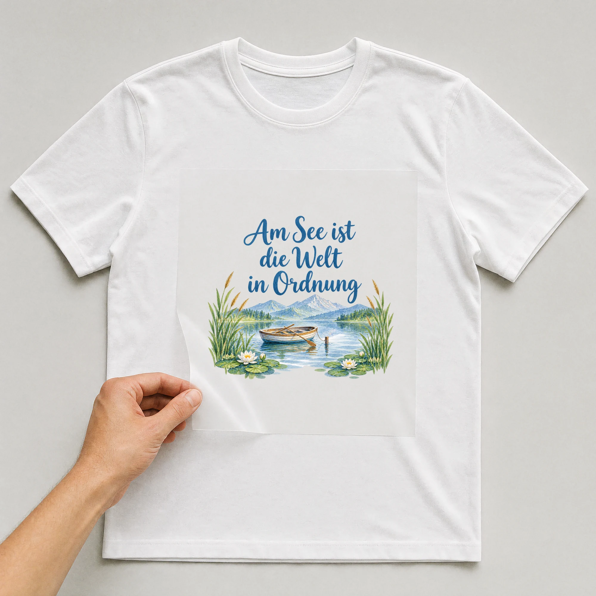 Bügelbild „Am See ist die Welt in Ordnung“ auf weißem T-Shirt, Folie wird aufgelegt