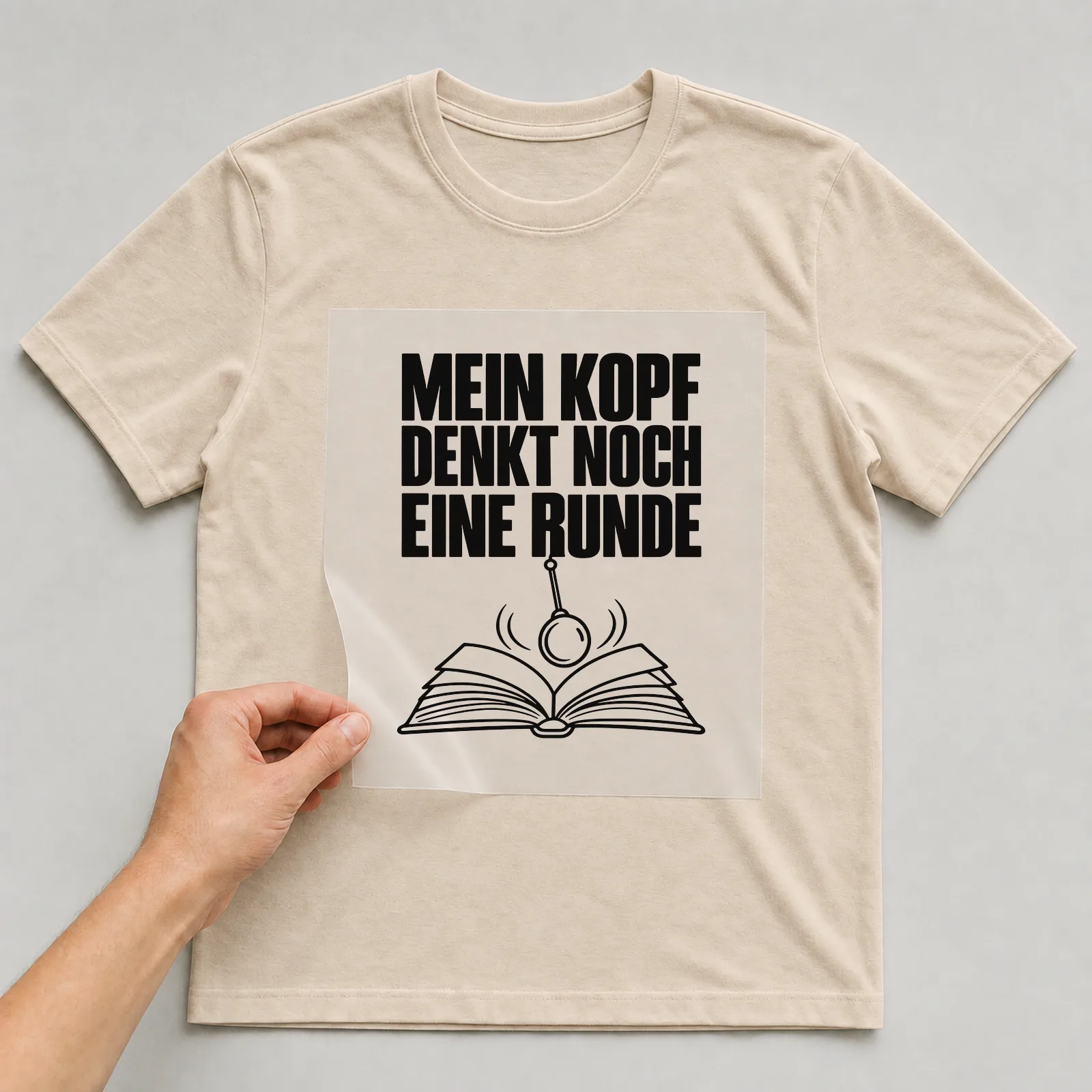 Bügelbild „Mein Kopf denkt noch eine Runde“ auf beigem T-Shirt, Folie wird aufgelegt