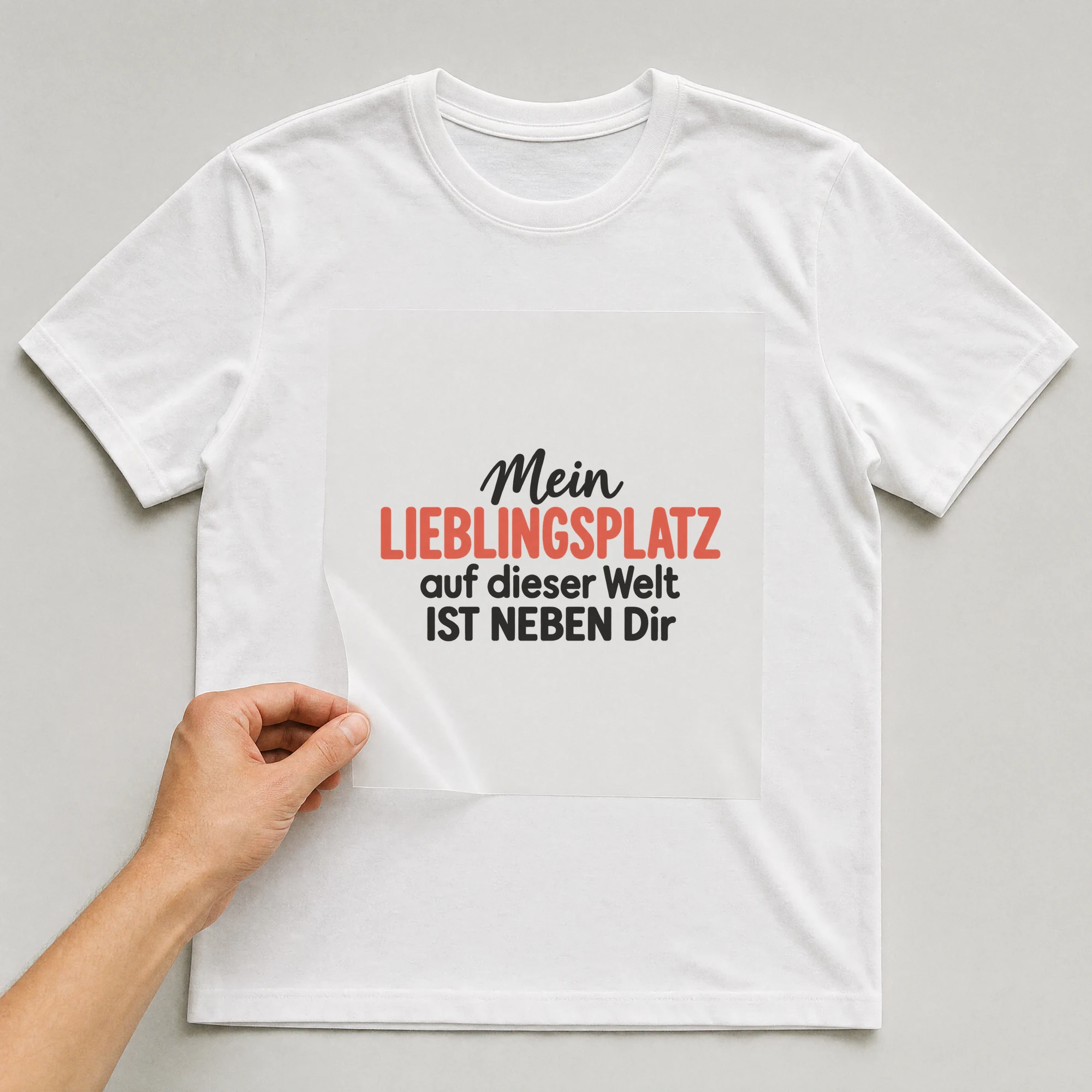 Bügelbild „Mein Lieblingsplatz auf dieser Welt ist neben dir“ auf weißem T-Shirt, Folie wird aufgelegt