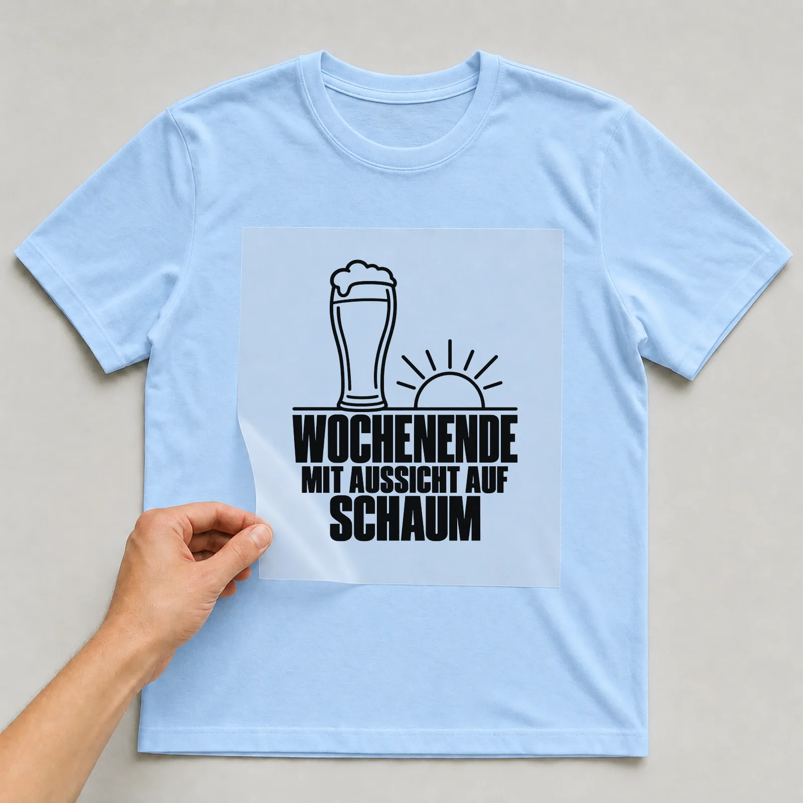 Bügelbild „Wochenende mit Aussicht auf Schaum“ auf hellblauem T-Shirt, Folie wird aufgelegt