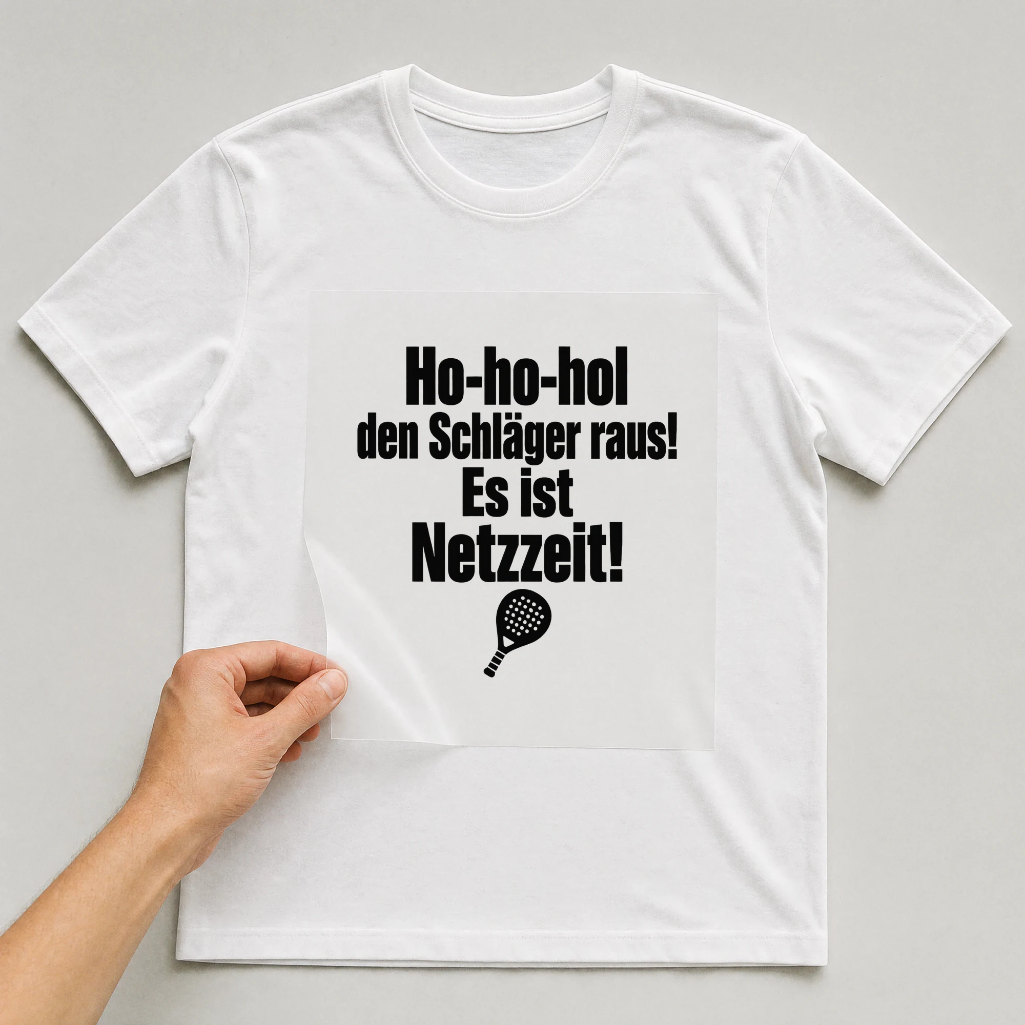 Bügelbild „Ho-ho-hol den Schläger raus! Es ist Netzzeit!“ auf weißem T-Shirt, Folie wird aufgelegt