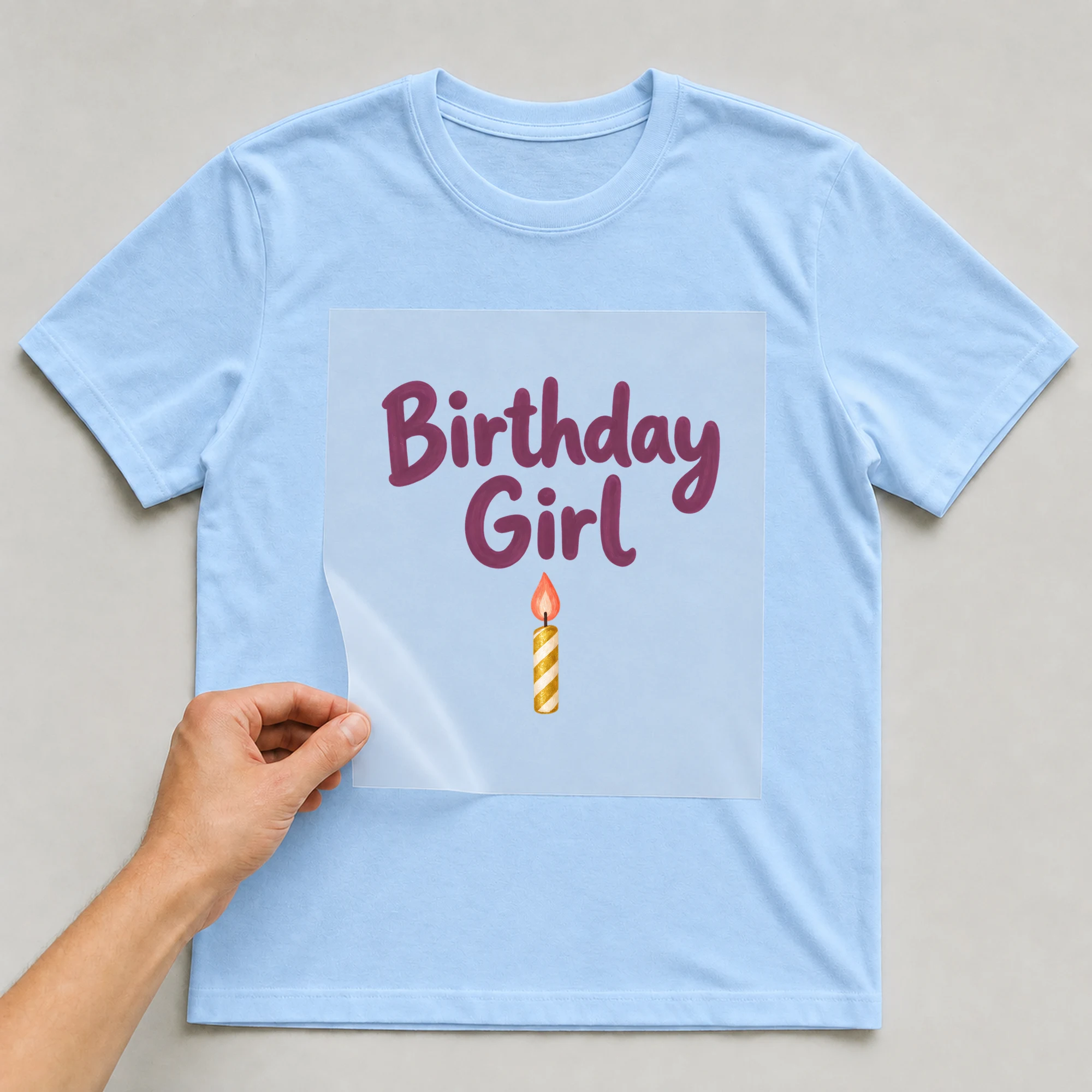 Bügelbild „Birthday Girl“ auf babyblauem T-Shirt, Folie wird aufgelegt