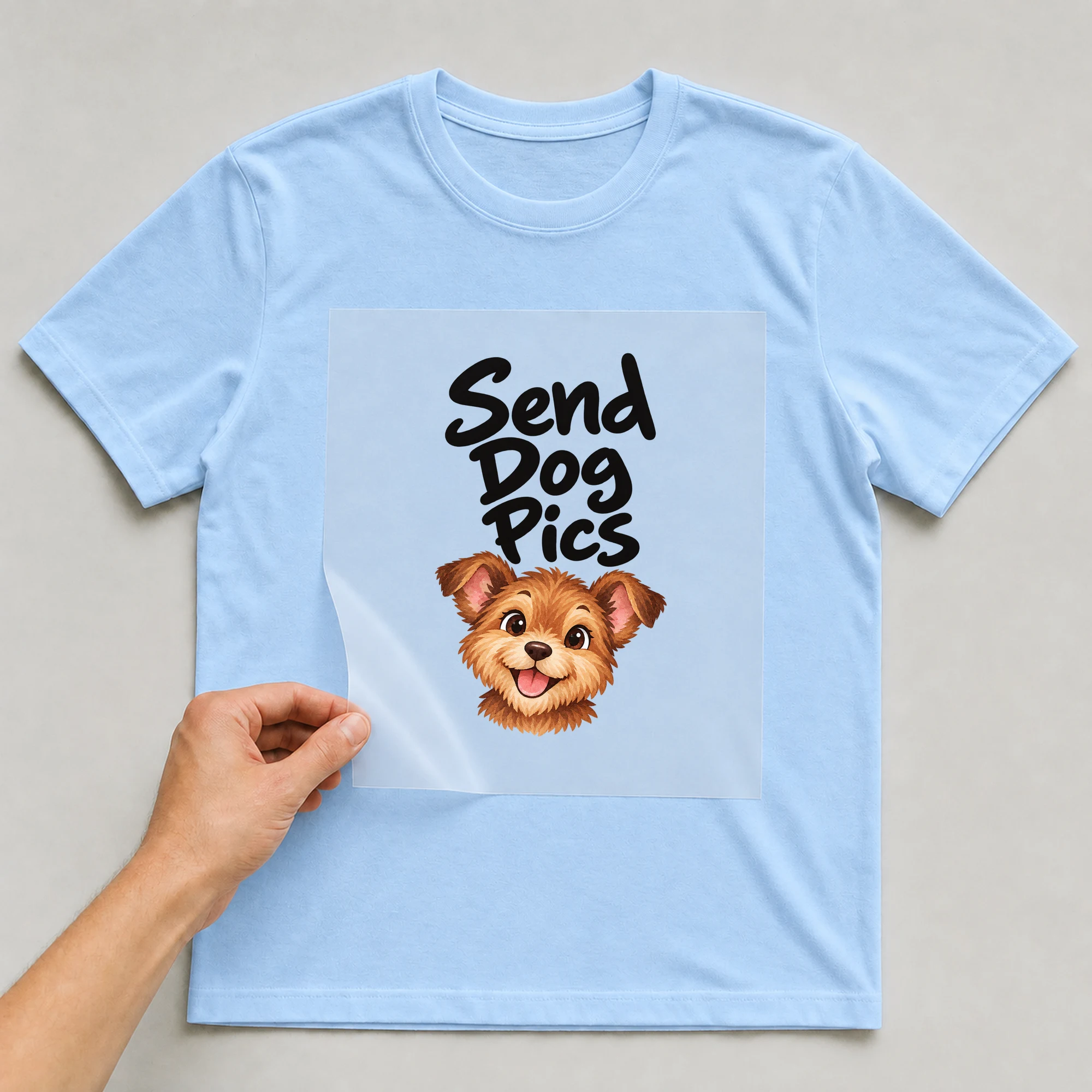 Bügelbild „Send Dog Pics“ auf babyblauem T-Shirt, Folie wird aufgelegt