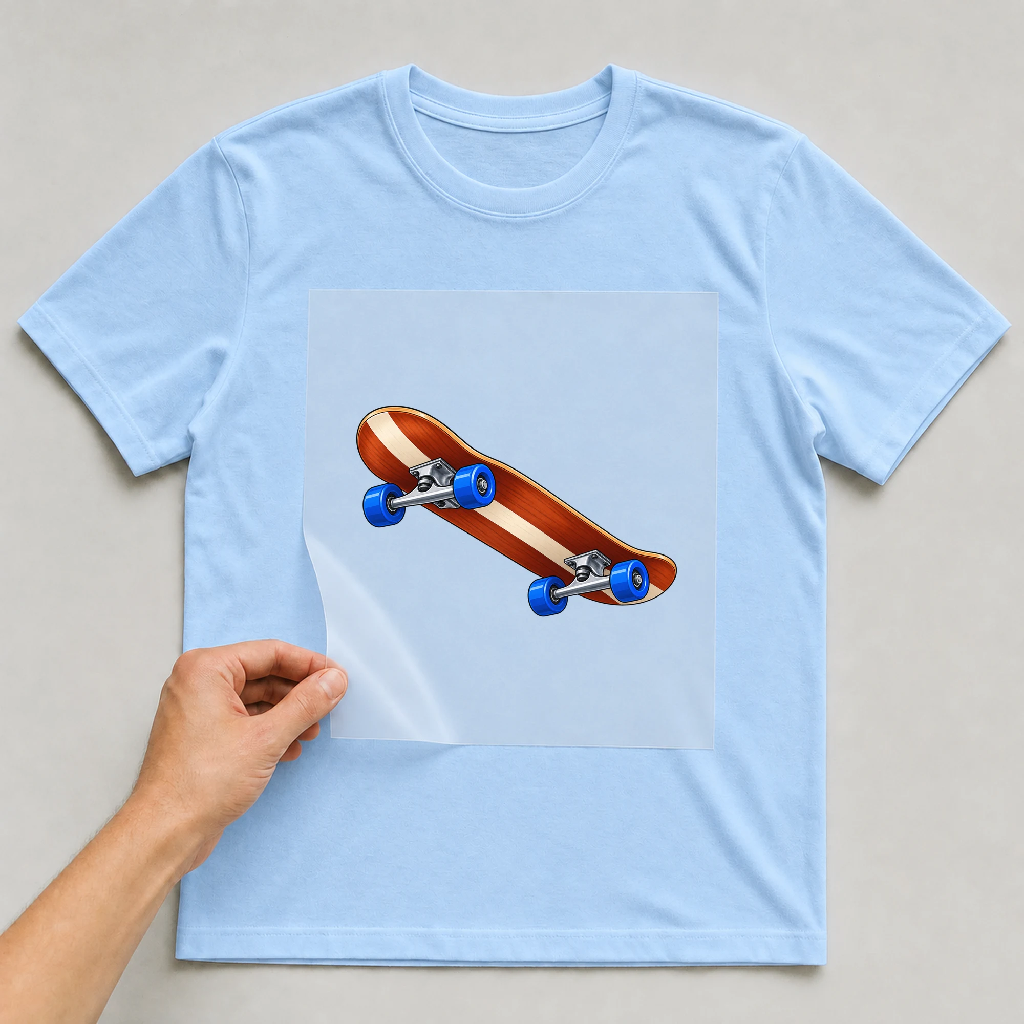 Bügelbild „Skateboard“ auf babyblauem T-Shirt, Folie wird aufgelegt