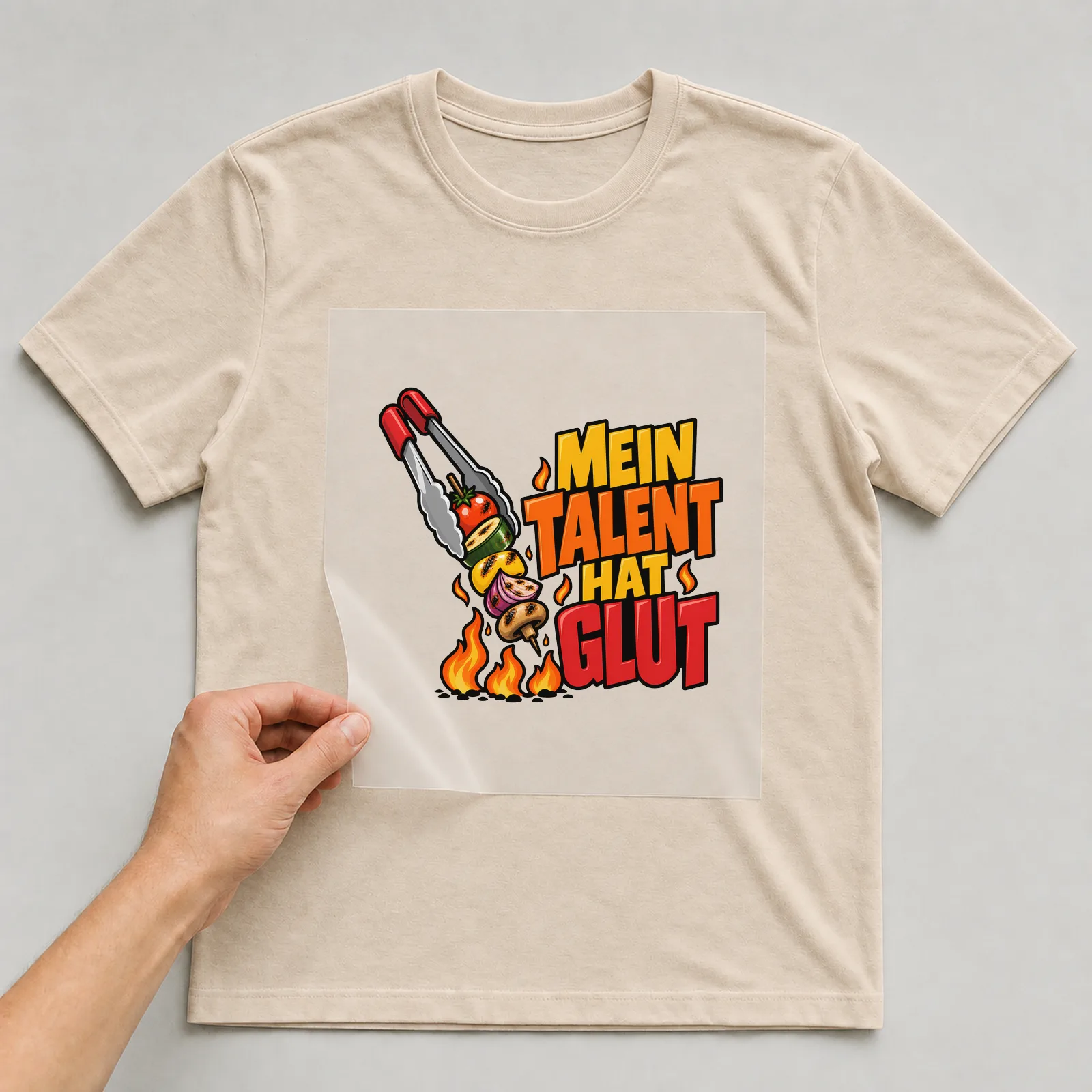 Bügelbild „Mein Talent hat Glut“ auf beigem T-Shirt, Folie wird aufgelegt