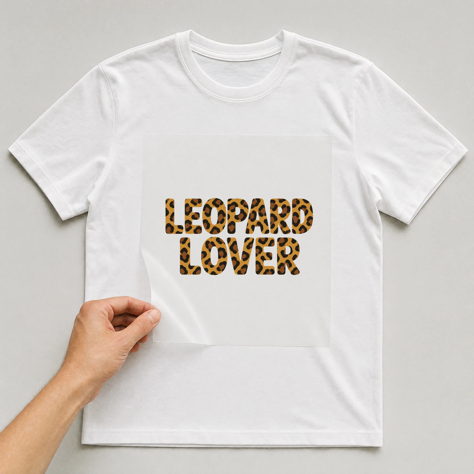Bügelbild „Leopard Lover“ auf weißem T-Shirt, Folie wird aufgelegt