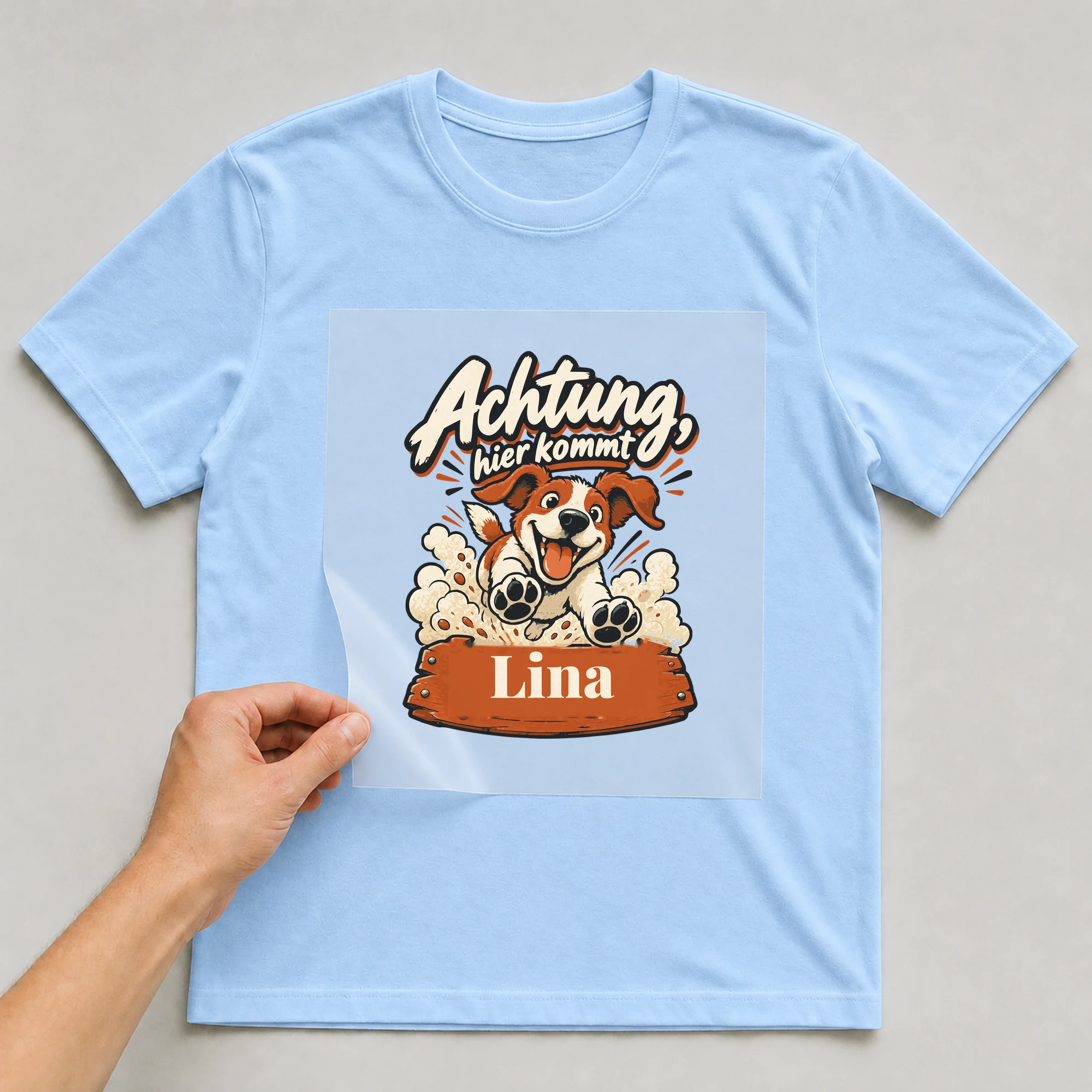 Bügelbild Achtung, hier kommt mit Name auf hellblauem T-Shirt, Folie wird aufgelegt