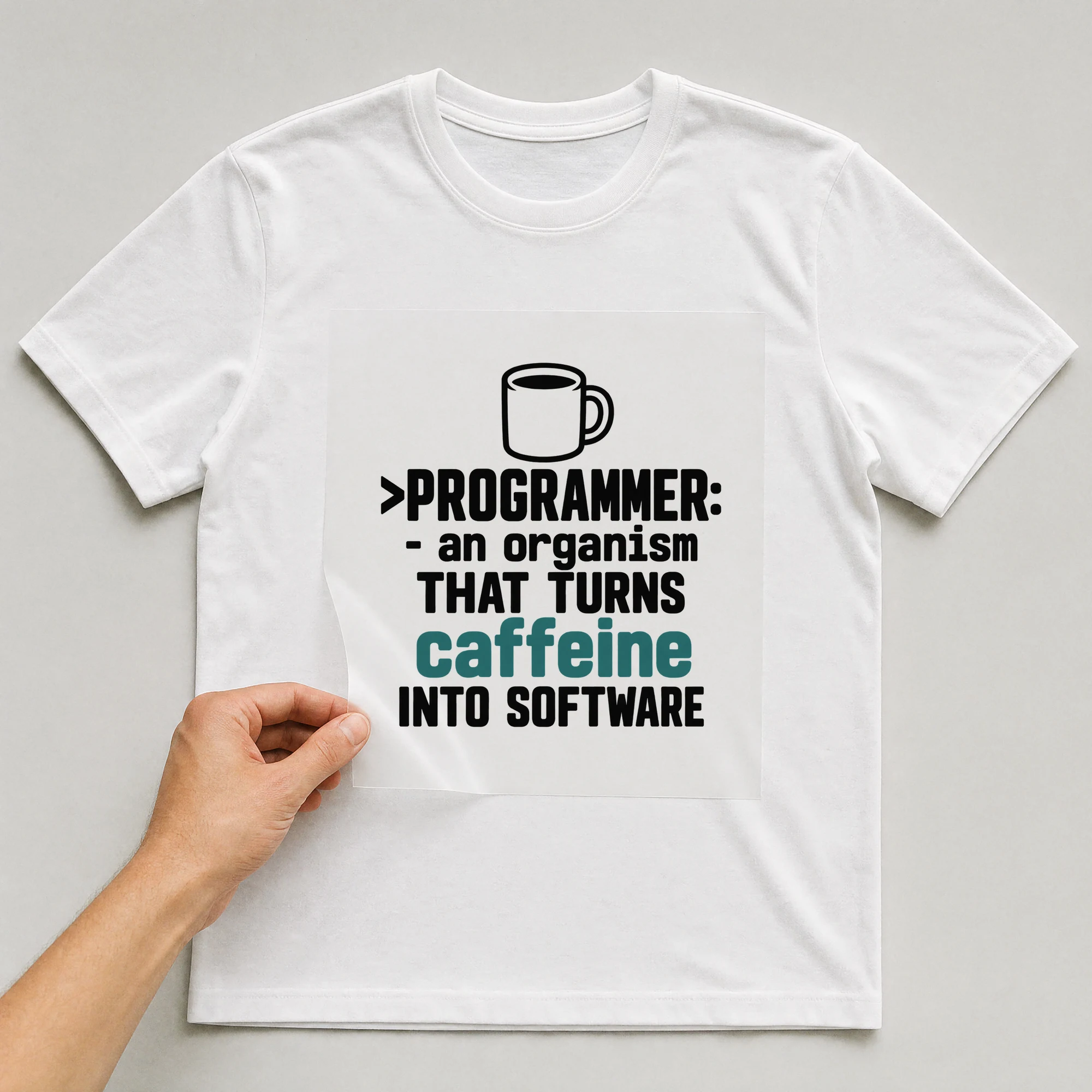 Bügelbild „>programmer: - An Organism That Turns Caffeine Into Software“ auf weißem T-Shirt, Folie wird aufgelegt