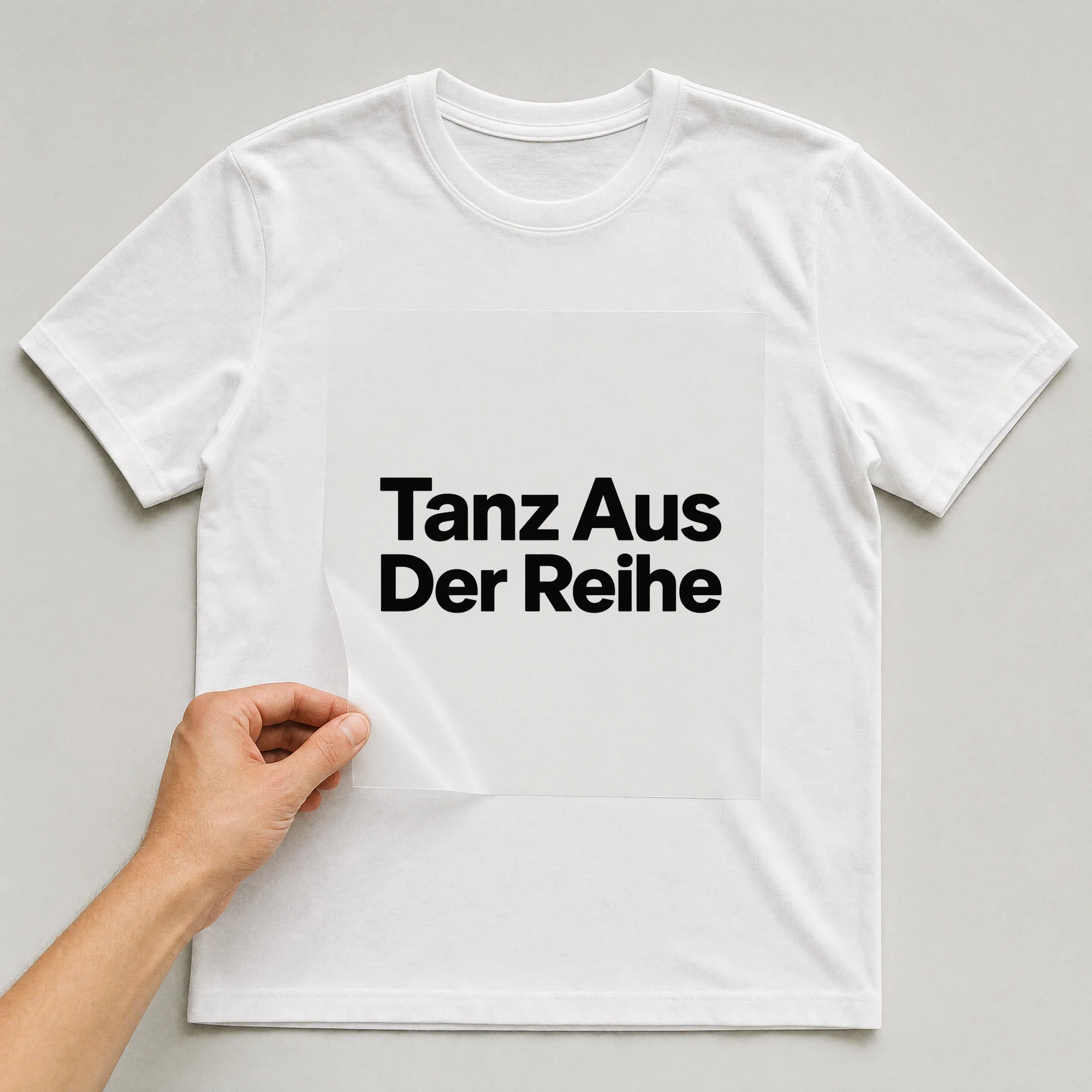 Bügelbild „Tanz aus der Reihe“ auf weißem T-Shirt, Folie wird aufgelegt