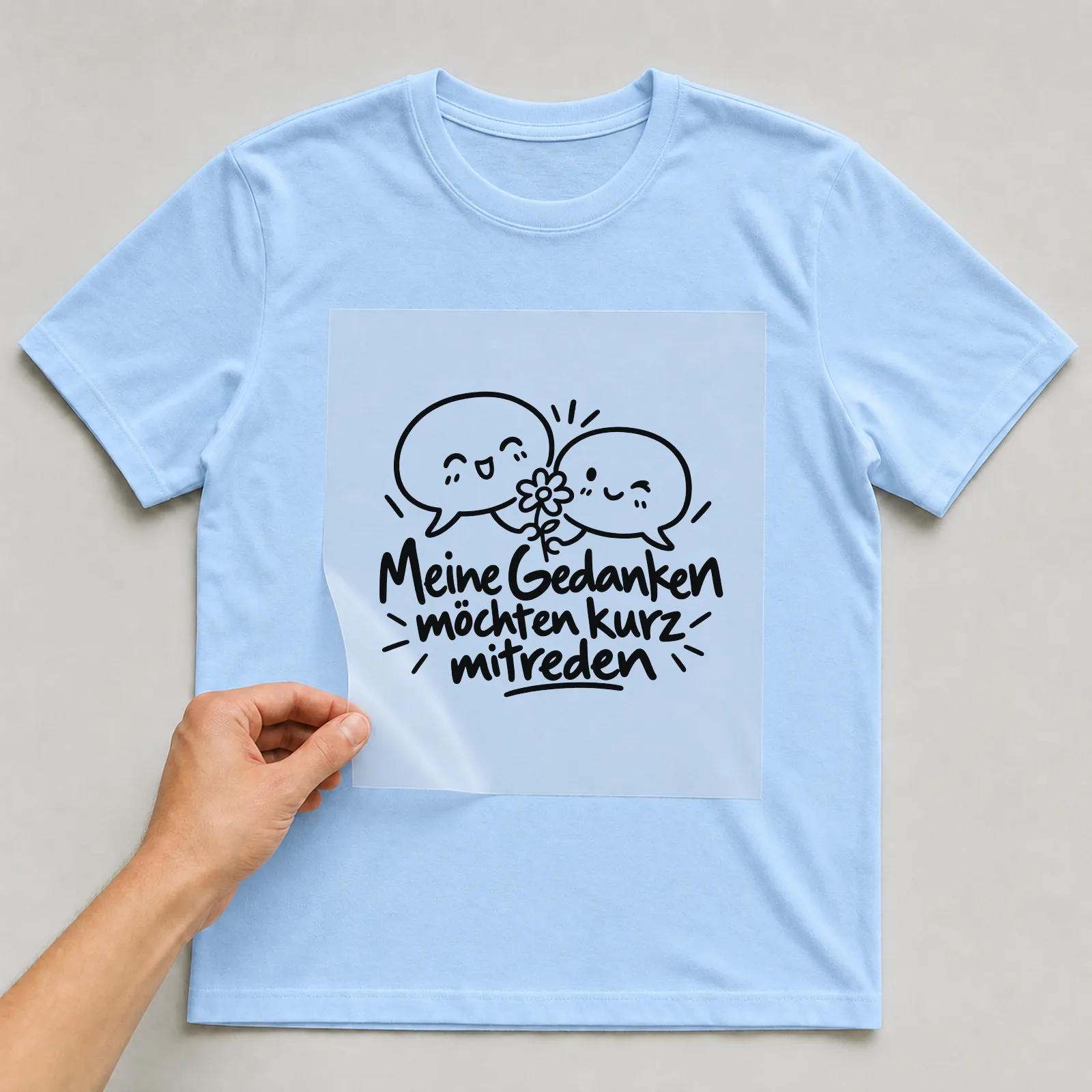 Bügelbild „Meine Gedanken möchten kurz mitreden“ auf hellblauem T-Shirt, Folie wird aufgelegt