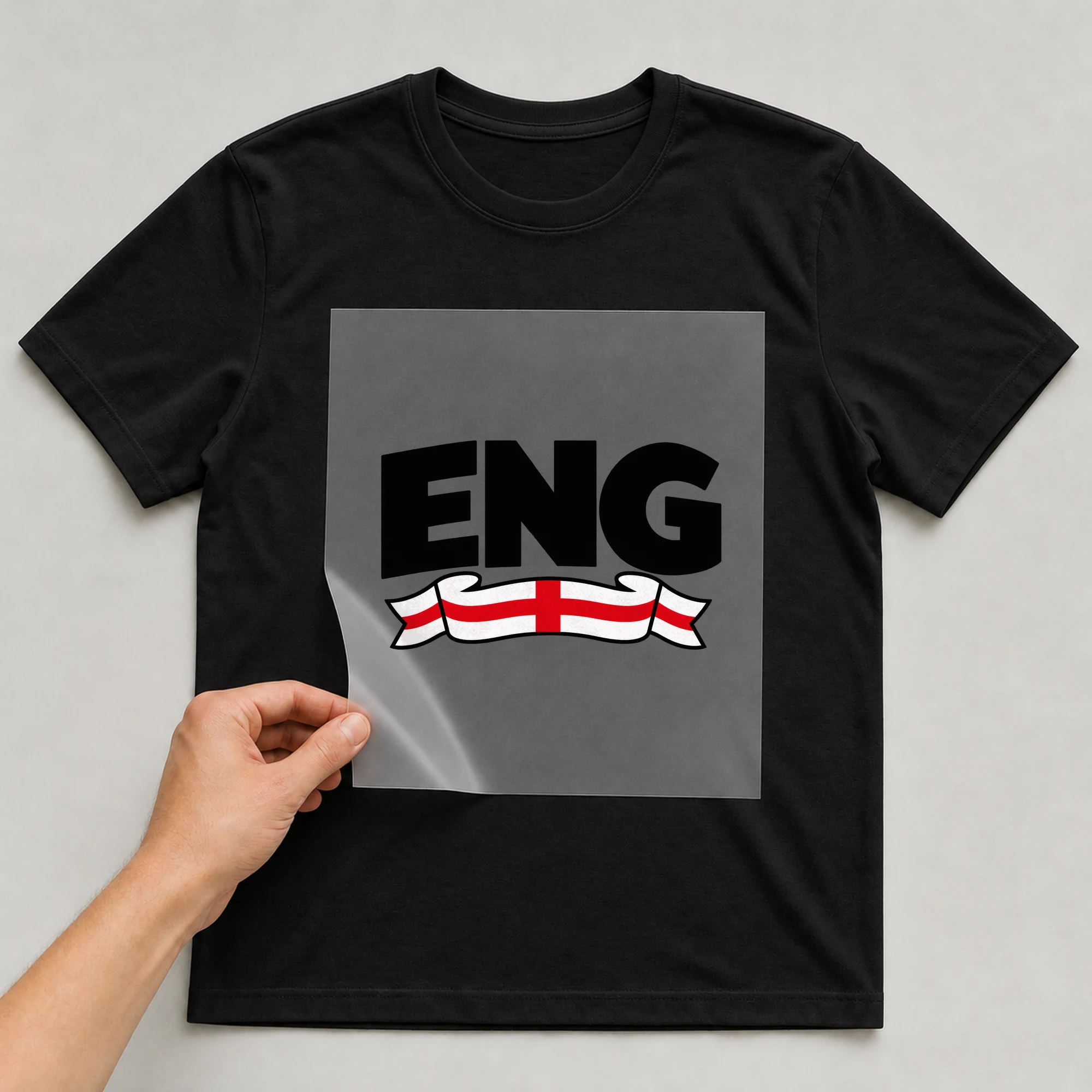 Bügelbild „ENG“ auf schwarzem T-Shirt, Folie wird aufgelegt