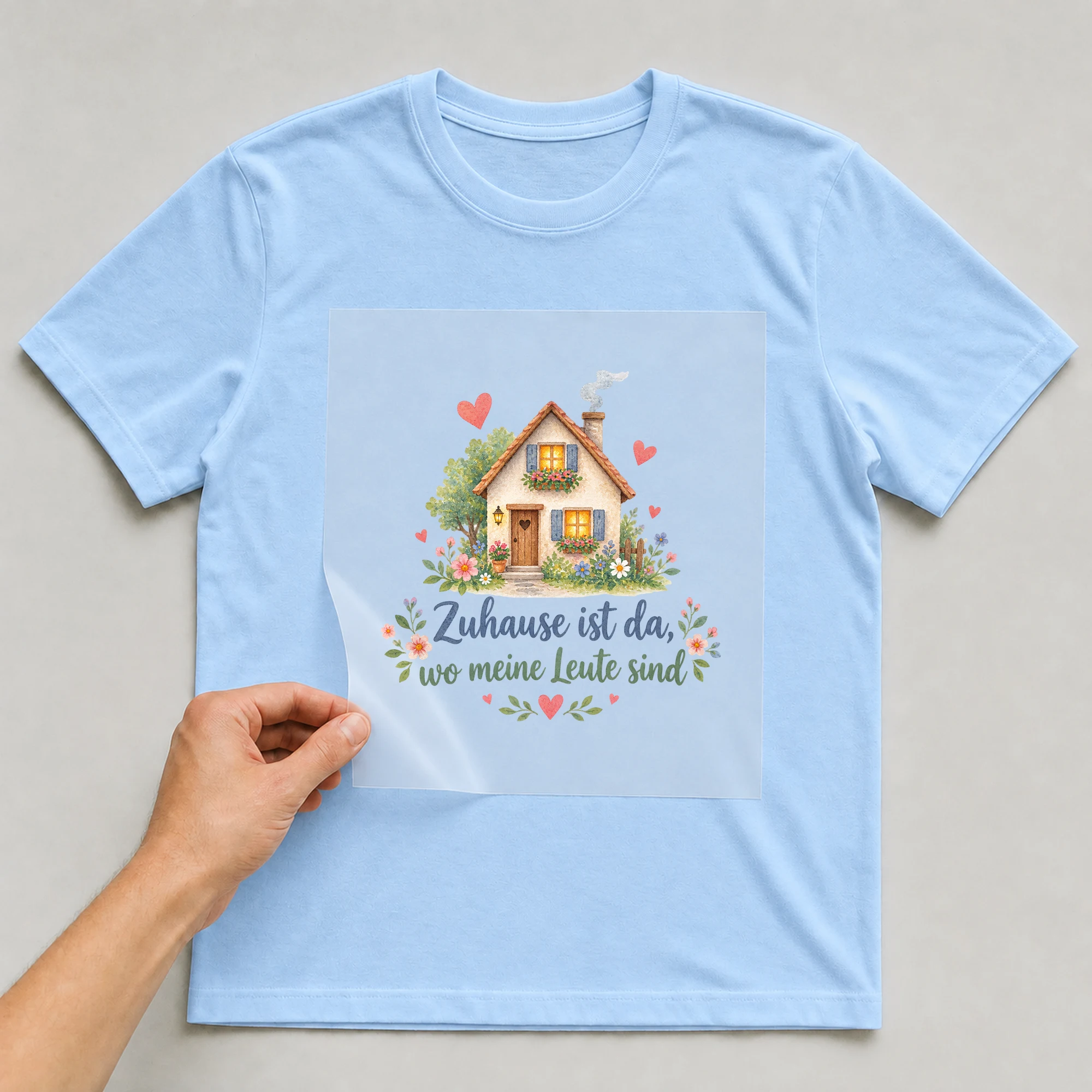 Bügelbild „Zuhause ist da, wo meine Leute sind“ auf babyblauem T-Shirt, Folie wird aufgelegt