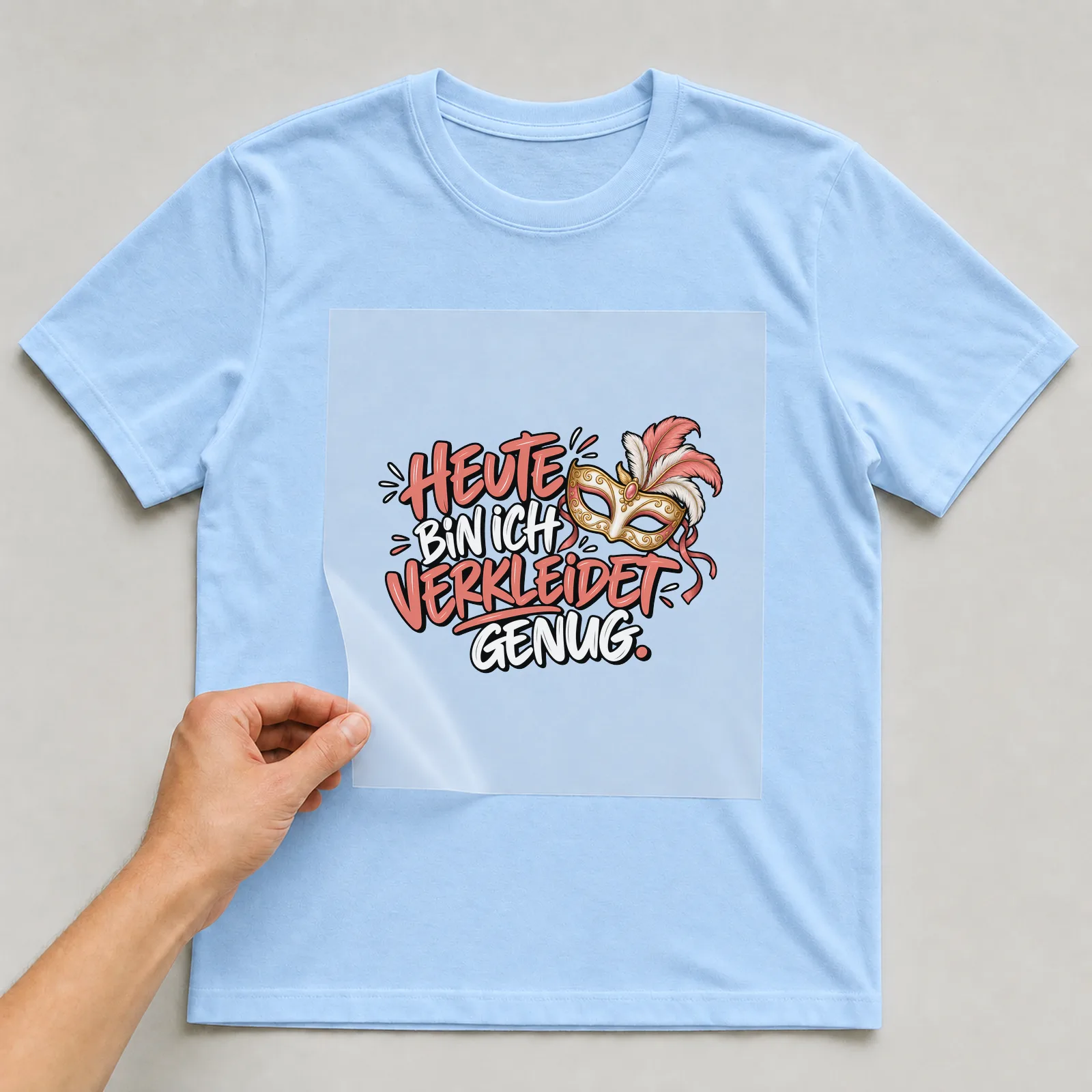 Bügelbild „Heute bin ich verkleidet genug“ auf hellblauem T-Shirt, Folie wird aufgelegt