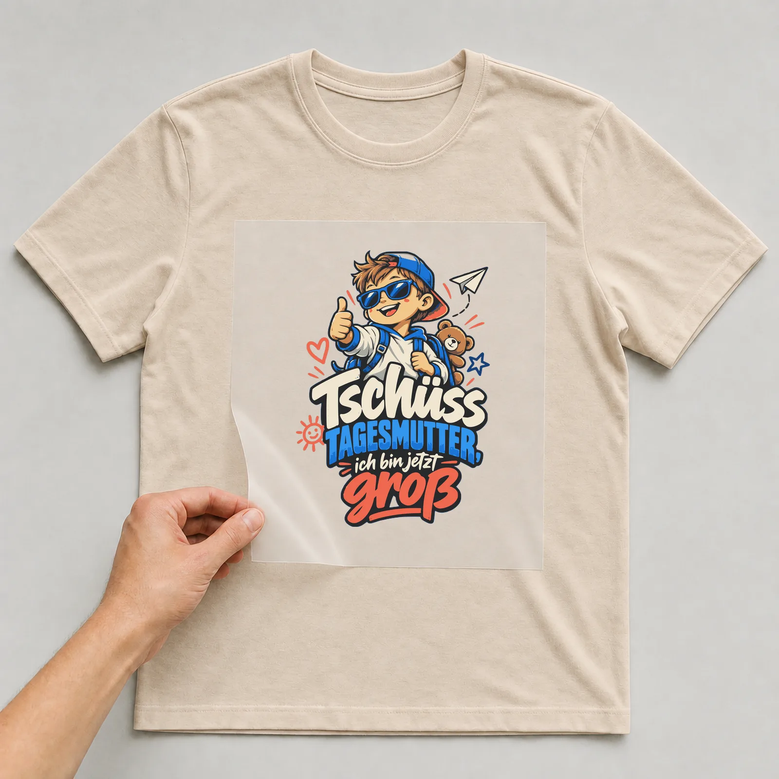Bügelbild Tschüss Tagesmutter, ich bin jetzt groß auf beigem T-Shirt, Folie wird aufgelegt