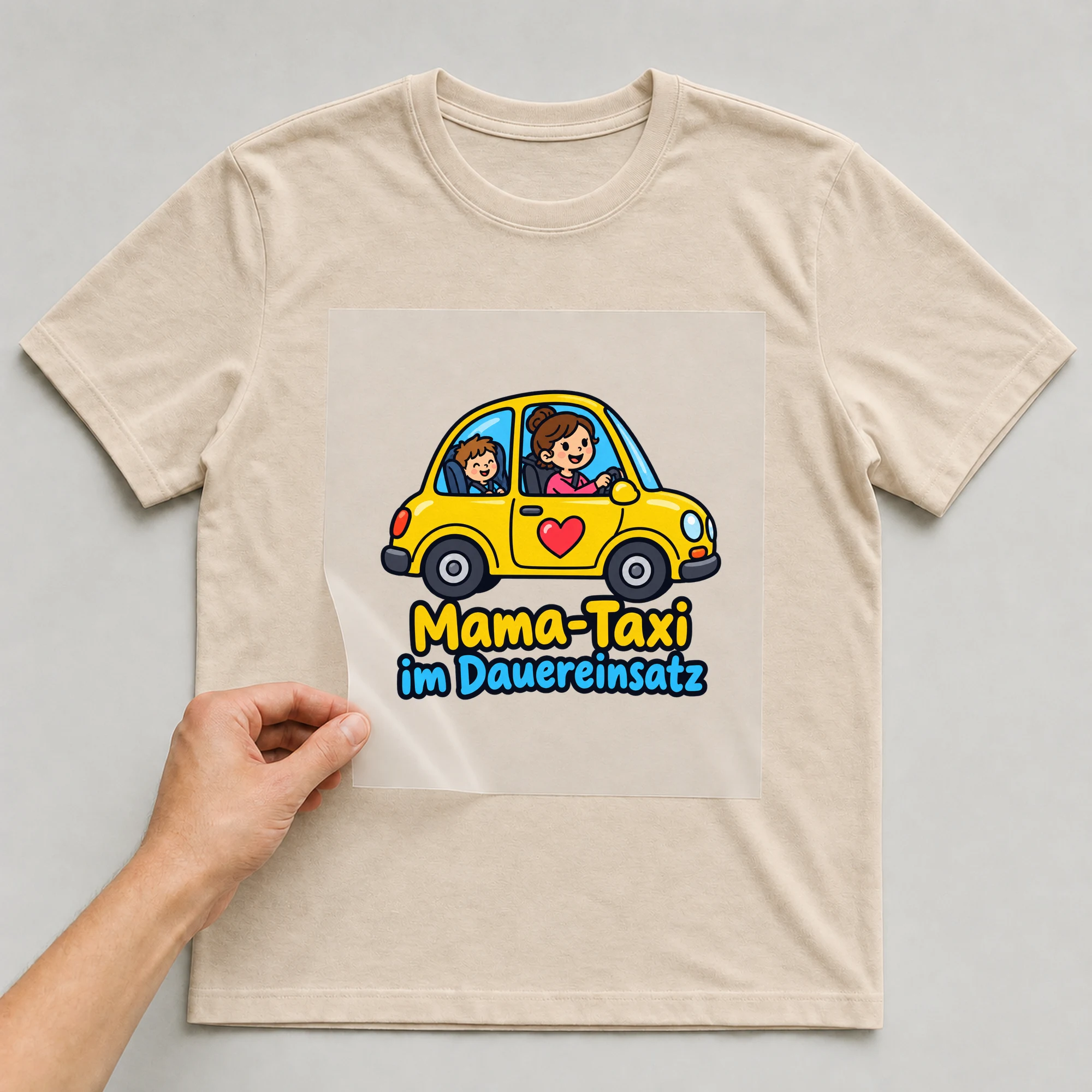 Bügelbild „Mama-Taxi im Dauereinsatz“ auf beigem T-Shirt, Folie wird aufgelegt