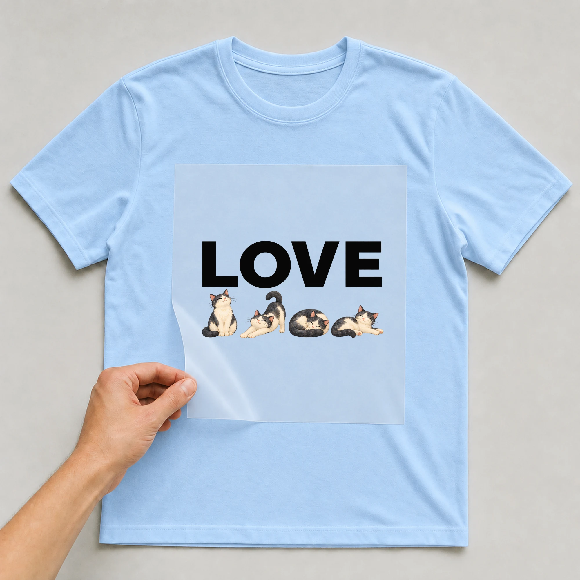 Bügelbild „Love“ auf babyblauem T-Shirt, Folie wird aufgelegt