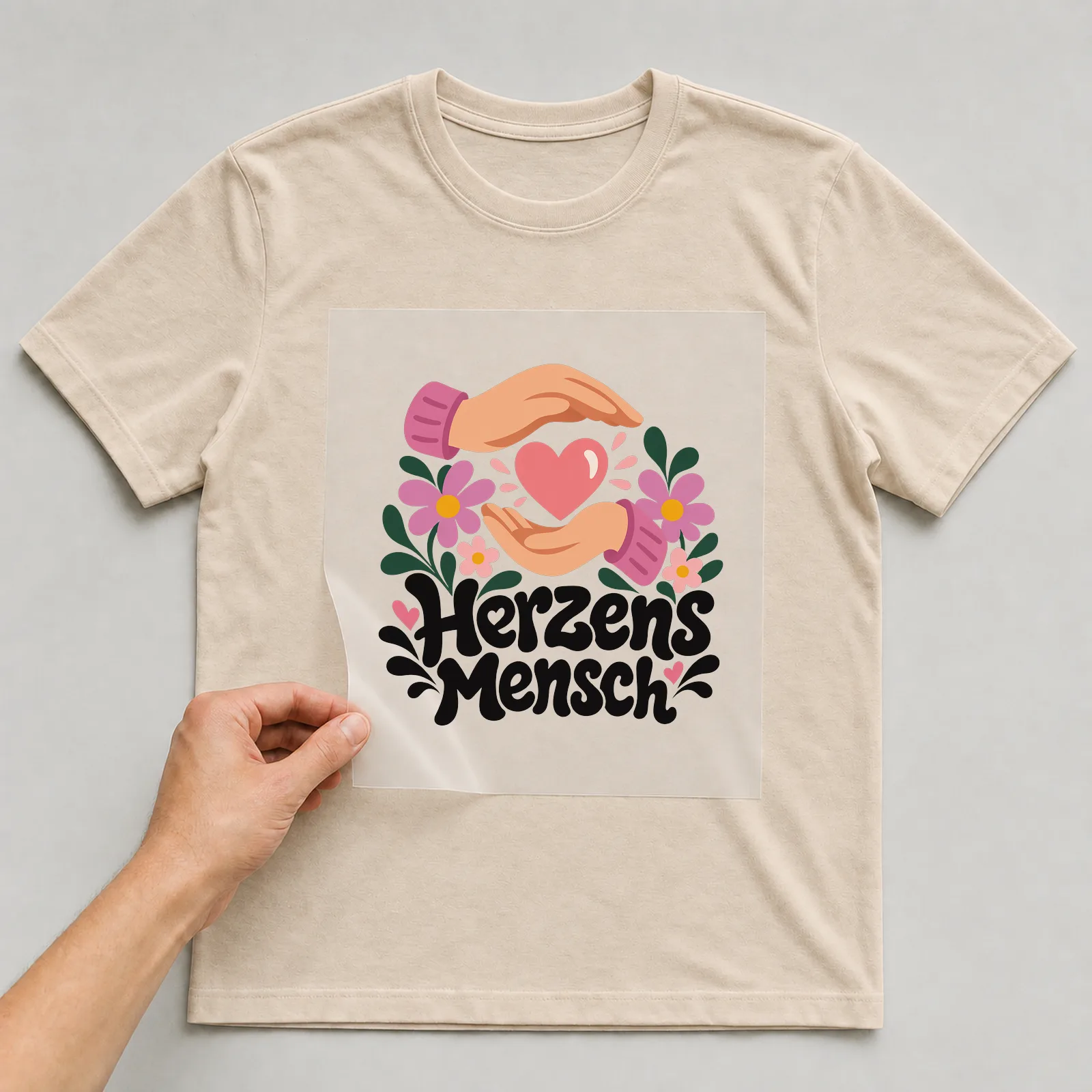 Bügelbild „Herzensmensch“ auf beigem T-Shirt, Folie wird aufgelegt
