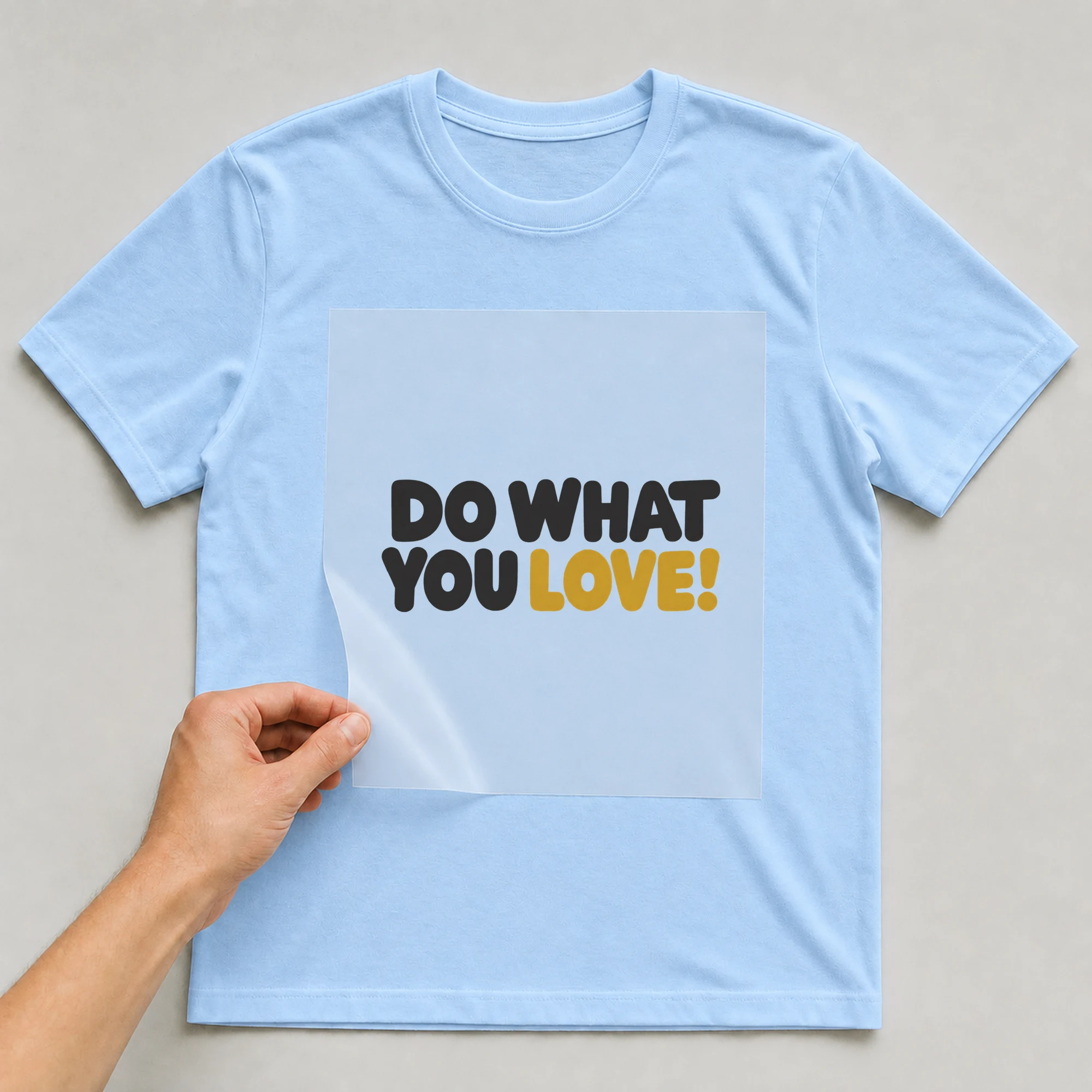 Bügelbild „Do What You Love!“ auf babyblauem T-Shirt, Folie wird aufgelegt