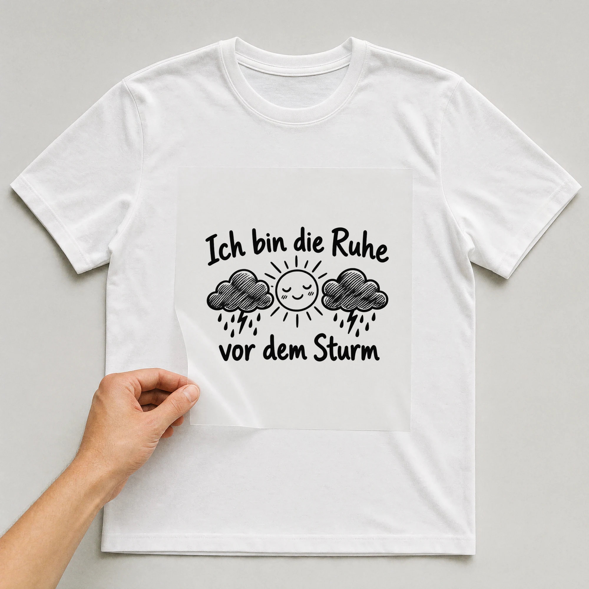 Bügelbild „Ich bin die Ruhe vor dem Sturm“ auf weißem T-Shirt, Folie wird aufgelegt