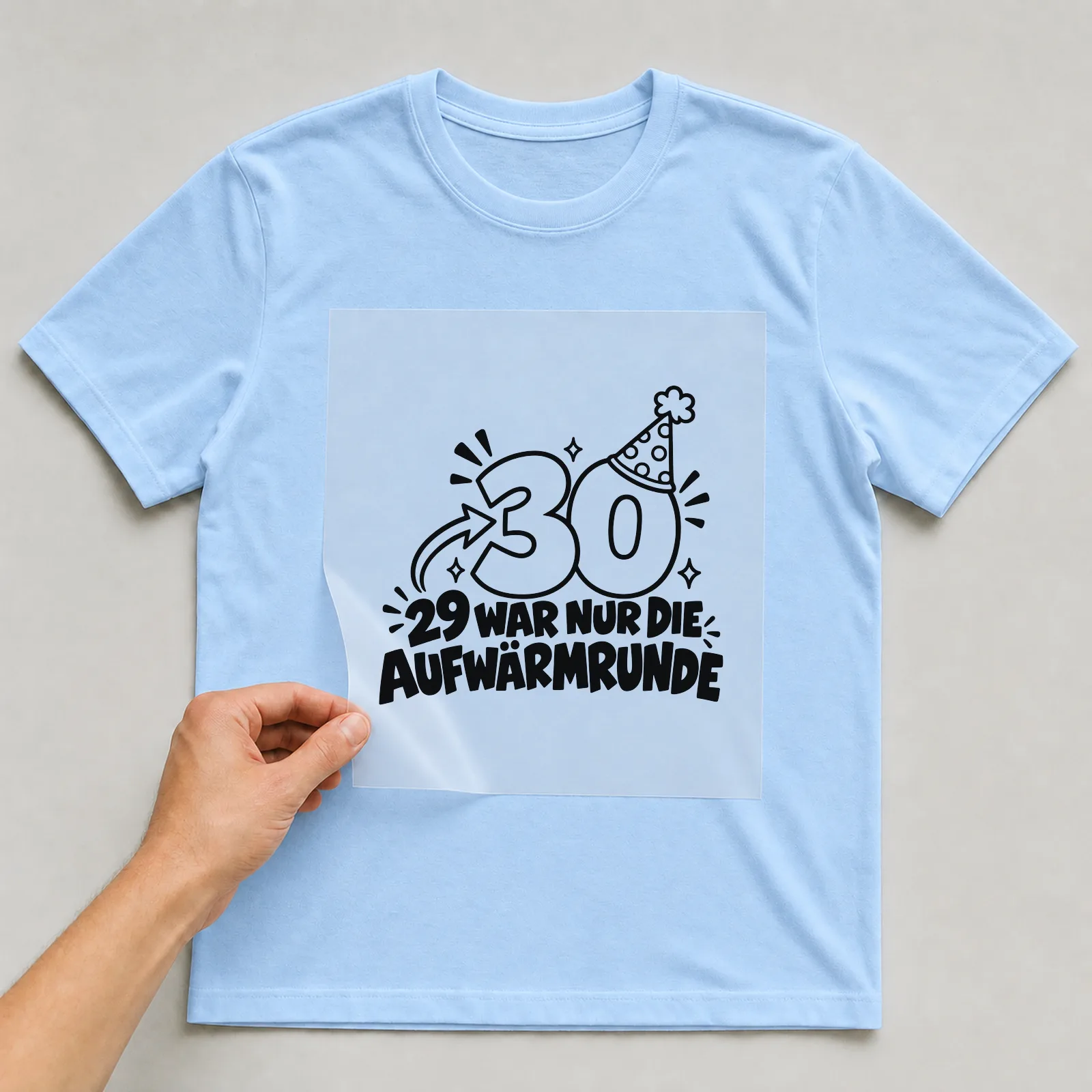 Bügelbild „29 War nur die Aufwärmrunde“ auf hellblauem T-Shirt, Folie wird aufgelegt