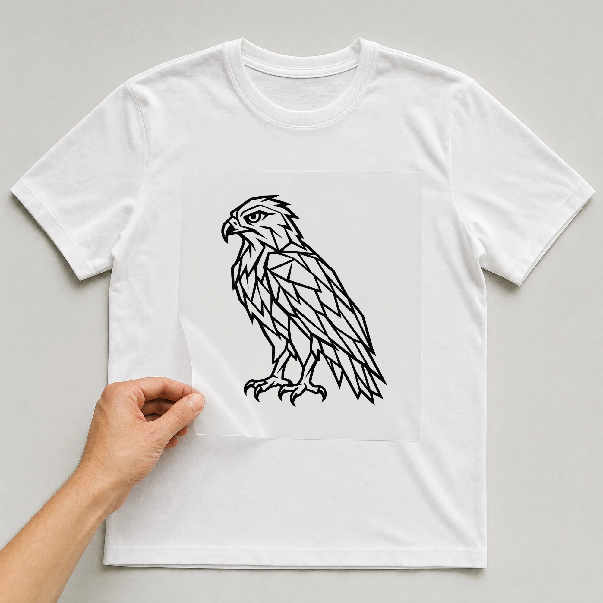 Bügelbild „Polygon Habicht“ auf weißem T-Shirt, Folie wird aufgelegt