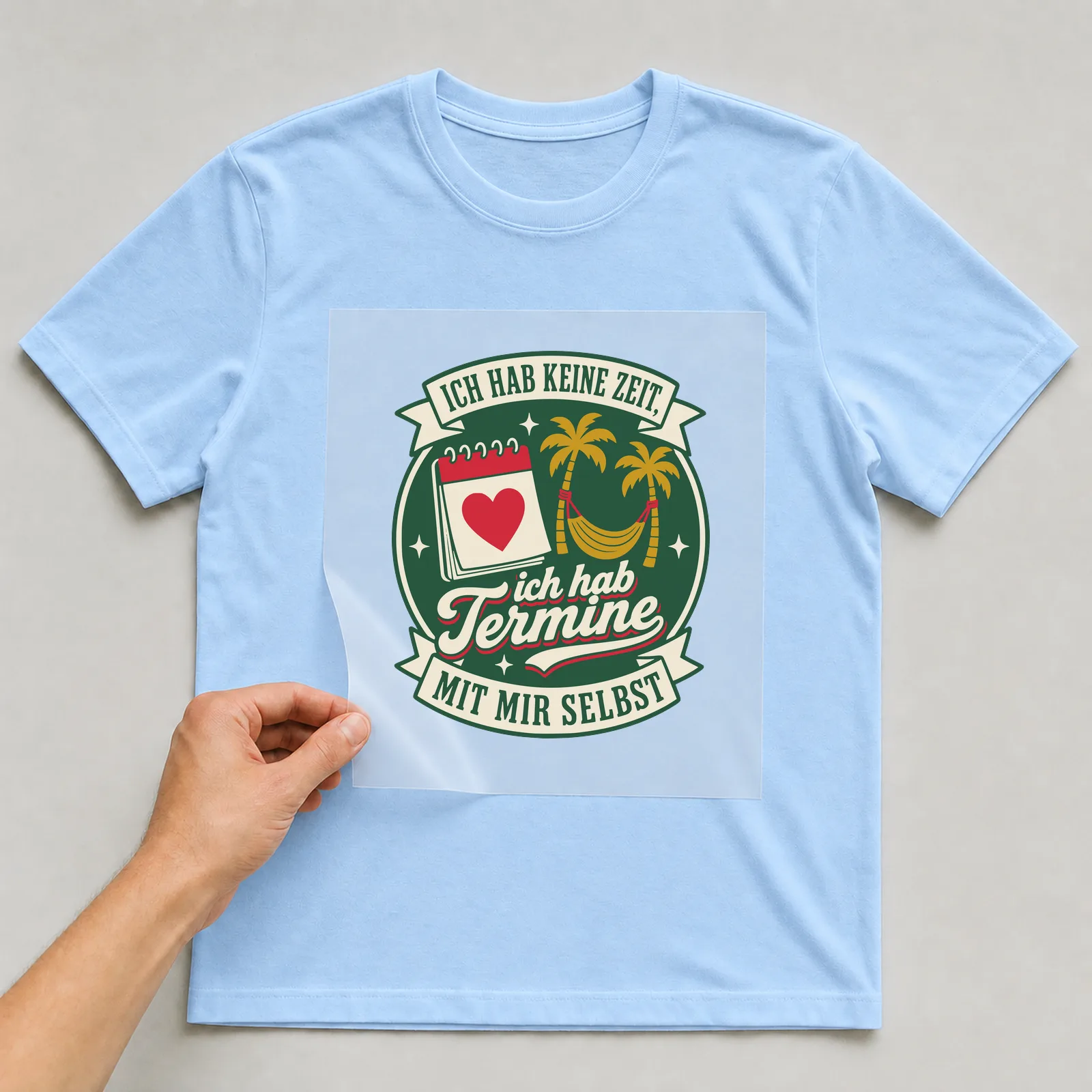 Bügelbild Ich hab keine Zeit, ich hab Termine mit mir selbst auf hellblauem T-Shirt, Folie wird aufgelegt