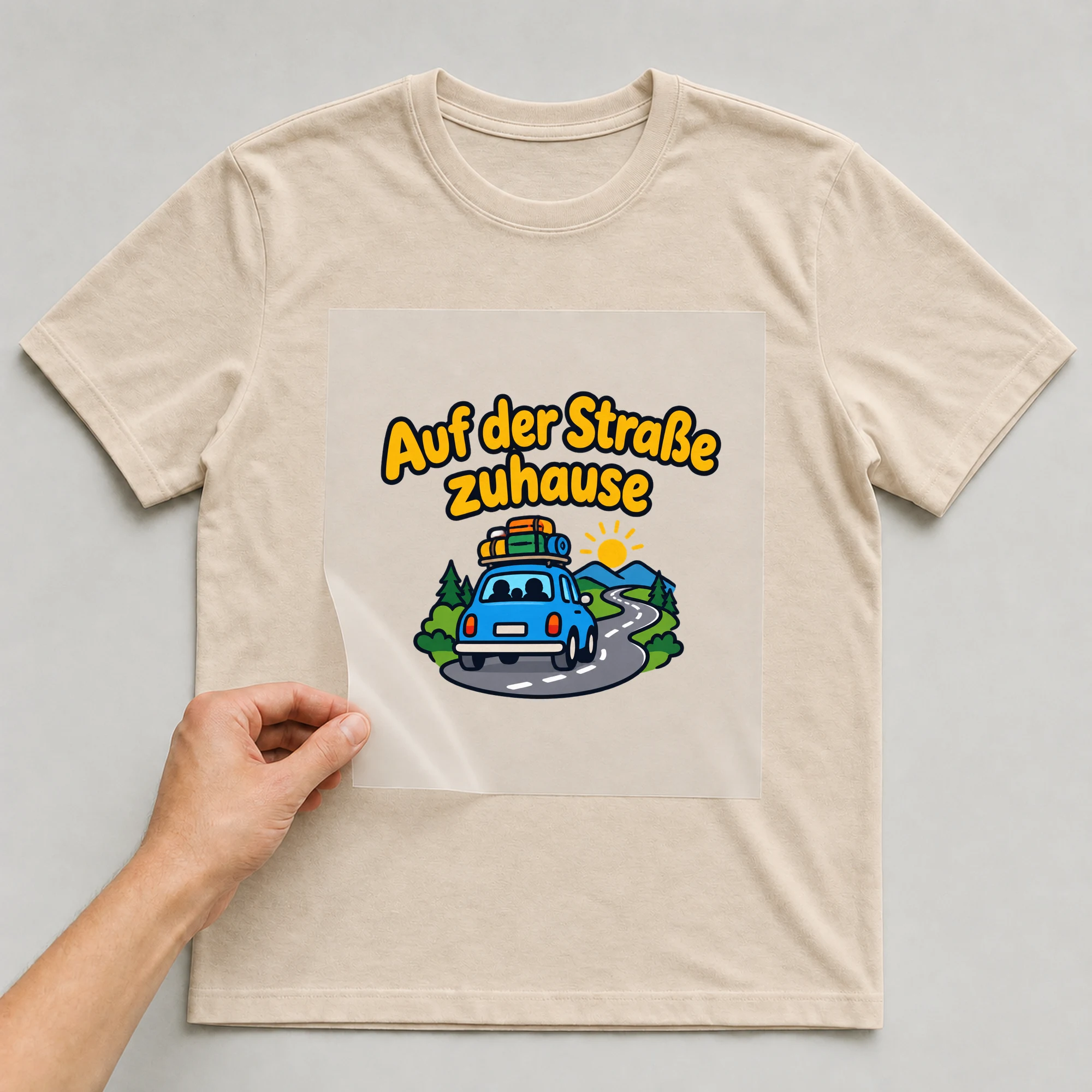 Bügelbild „Auf der Straße zuhause“ auf beigem T-Shirt, Folie wird aufgelegt
