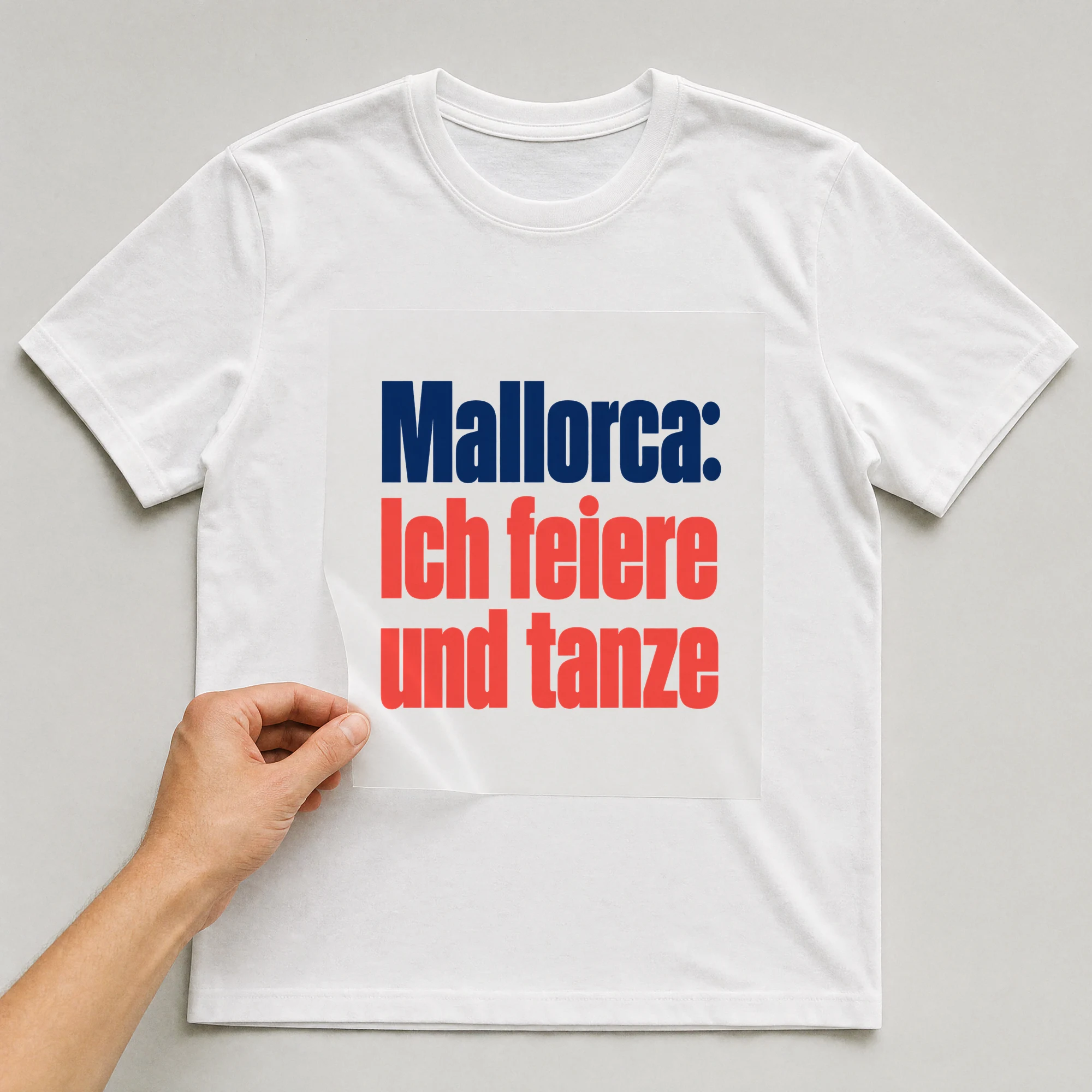 Bügelbild „Mallorca: Ich feiere und tanze“ auf weißem T-Shirt, Folie wird aufgelegt