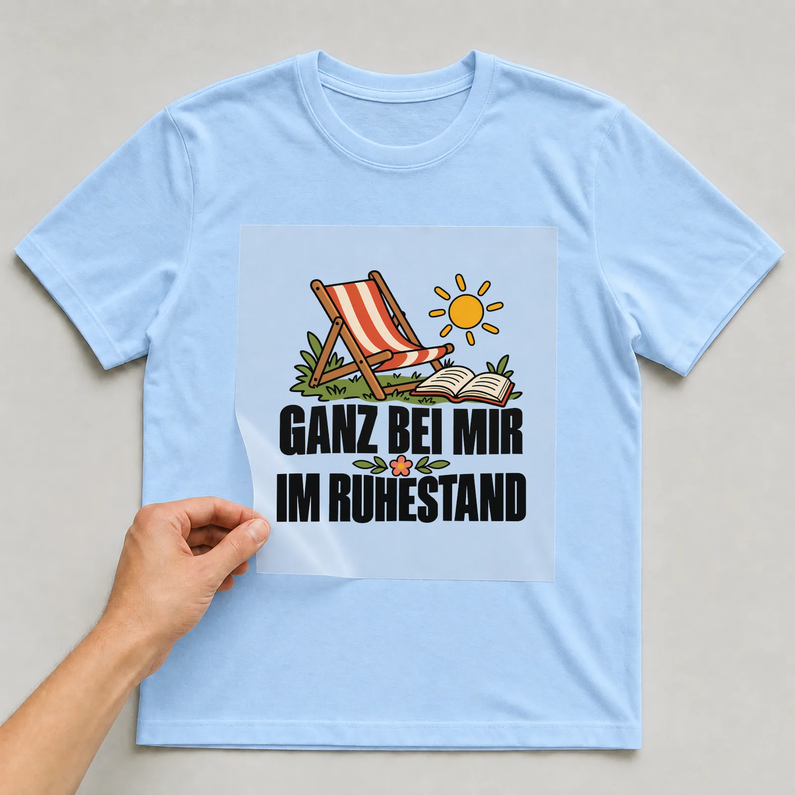 Bügelbild „Ganz bei mir im Ruhestand“ auf hellblauem T-Shirt, Folie wird aufgelegt