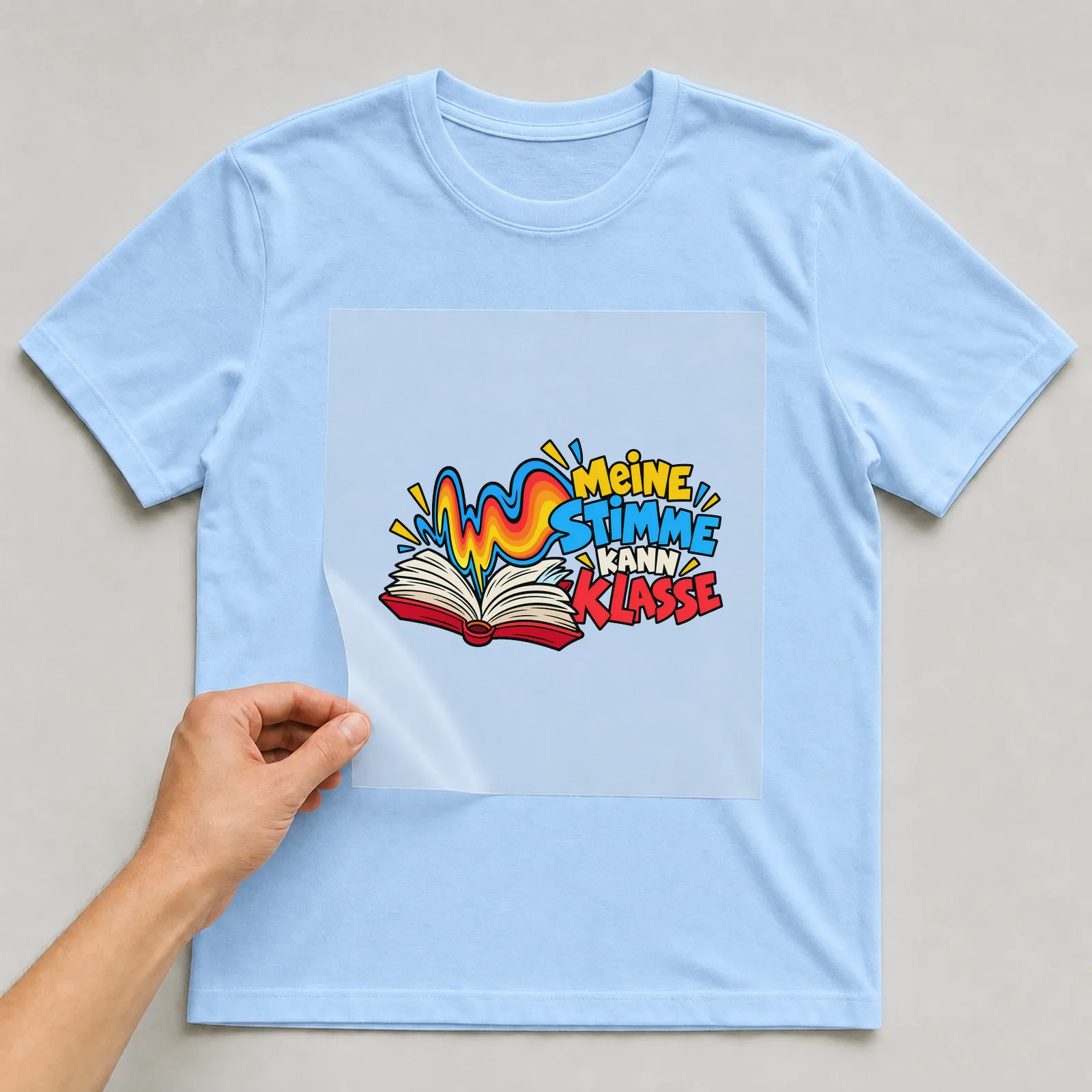 Bügelbild „Meine Stimme kann Klasse“ auf hellblauem T-Shirt, Folie wird aufgelegt
