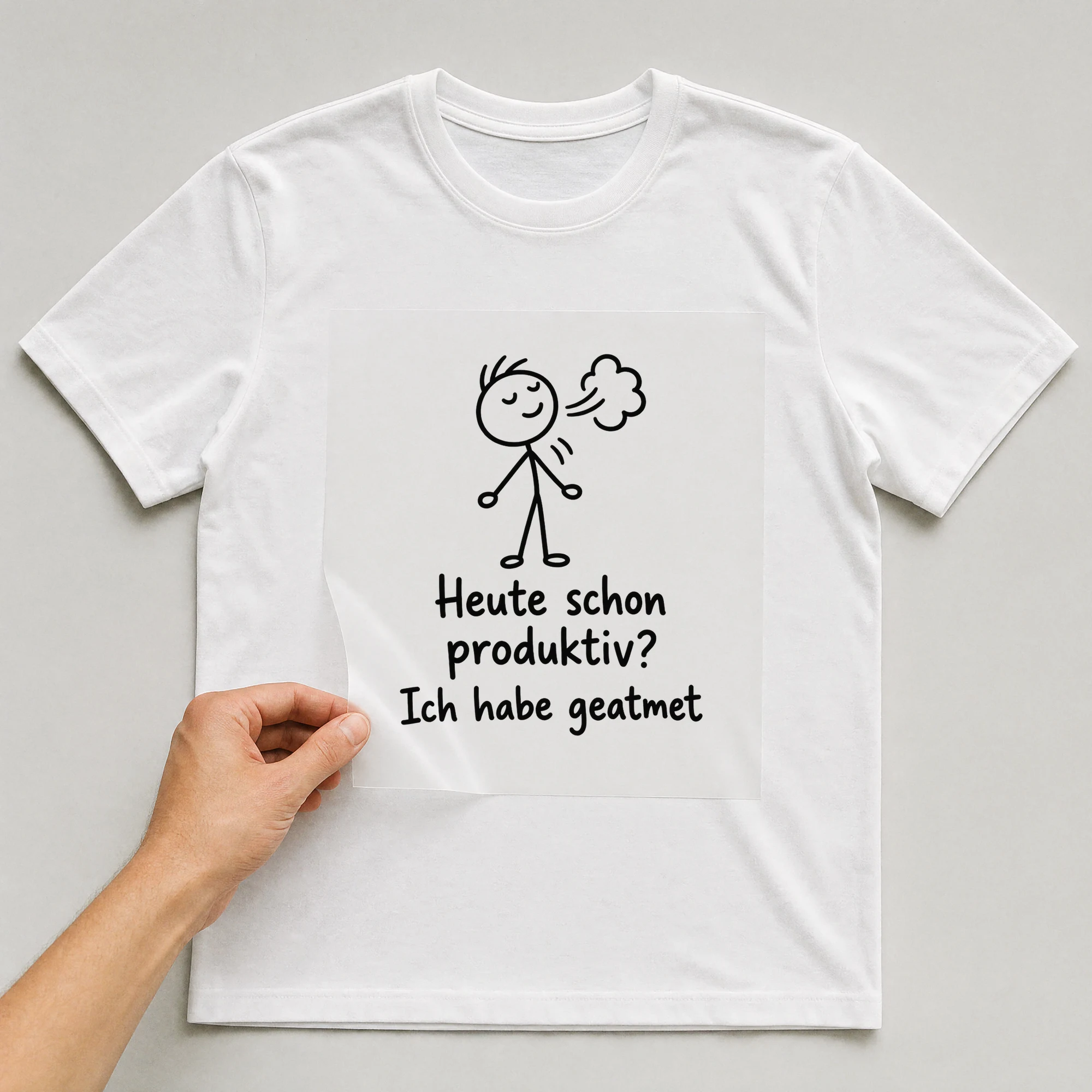 Bügelbild „Heute schon produktiv? Ich habe geatmet“ auf weißem T-Shirt, Folie wird aufgelegt