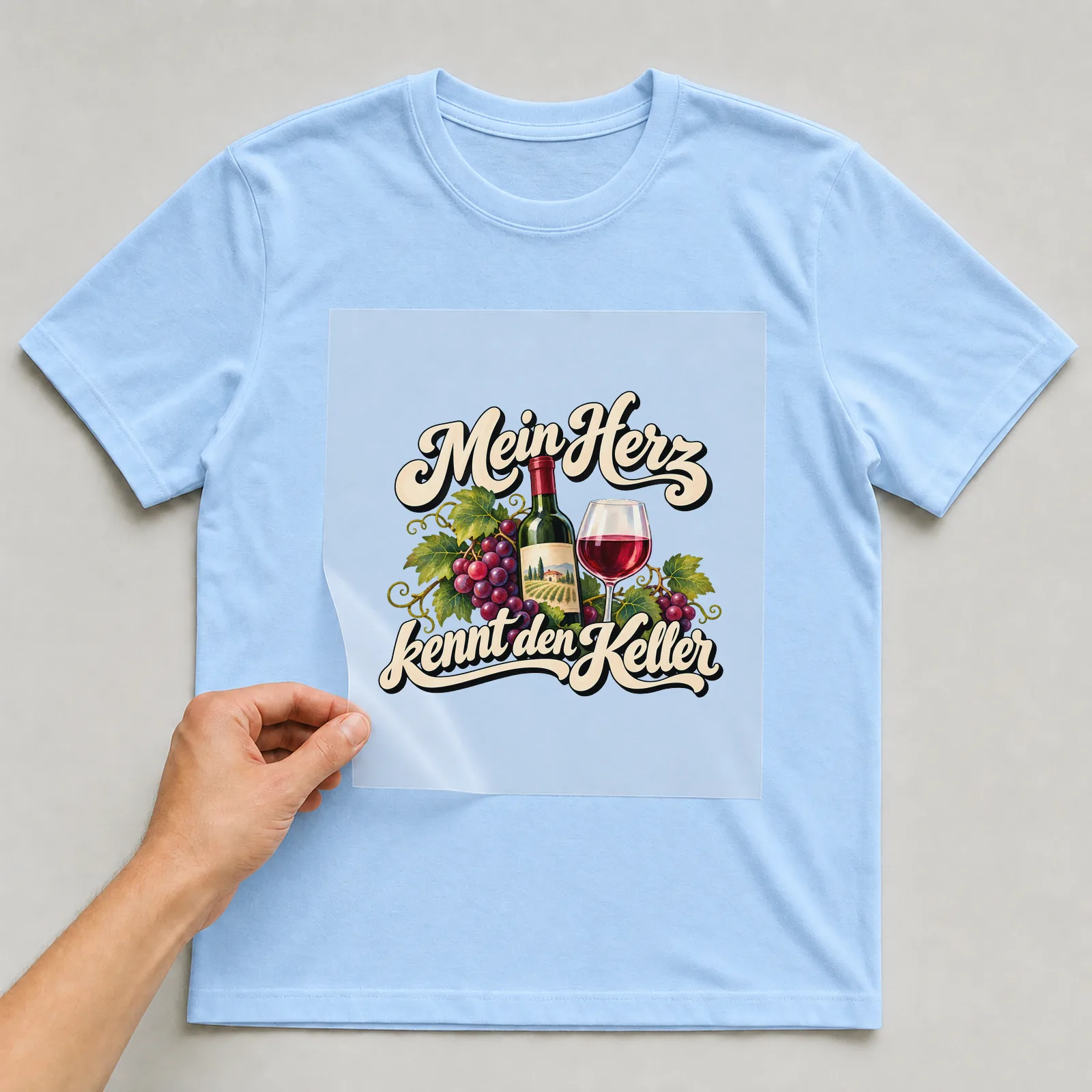 Bügelbild „Mein Herz kennt den Keller“ auf hellblauem T-Shirt, Folie wird aufgelegt