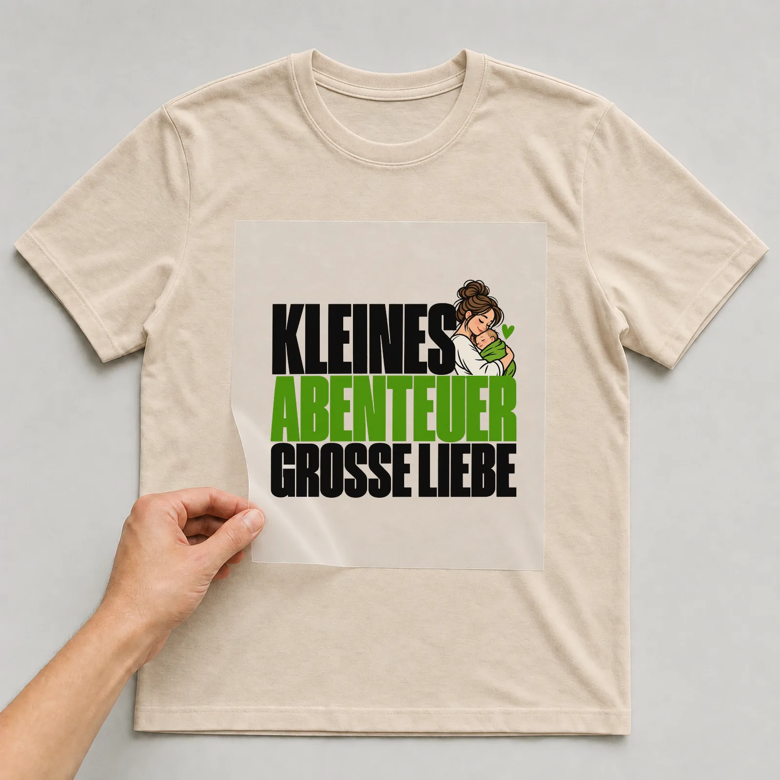 Bügelbild „Kleines Abenteuer große Liebe“ auf beigem T-Shirt, Folie wird aufgelegt